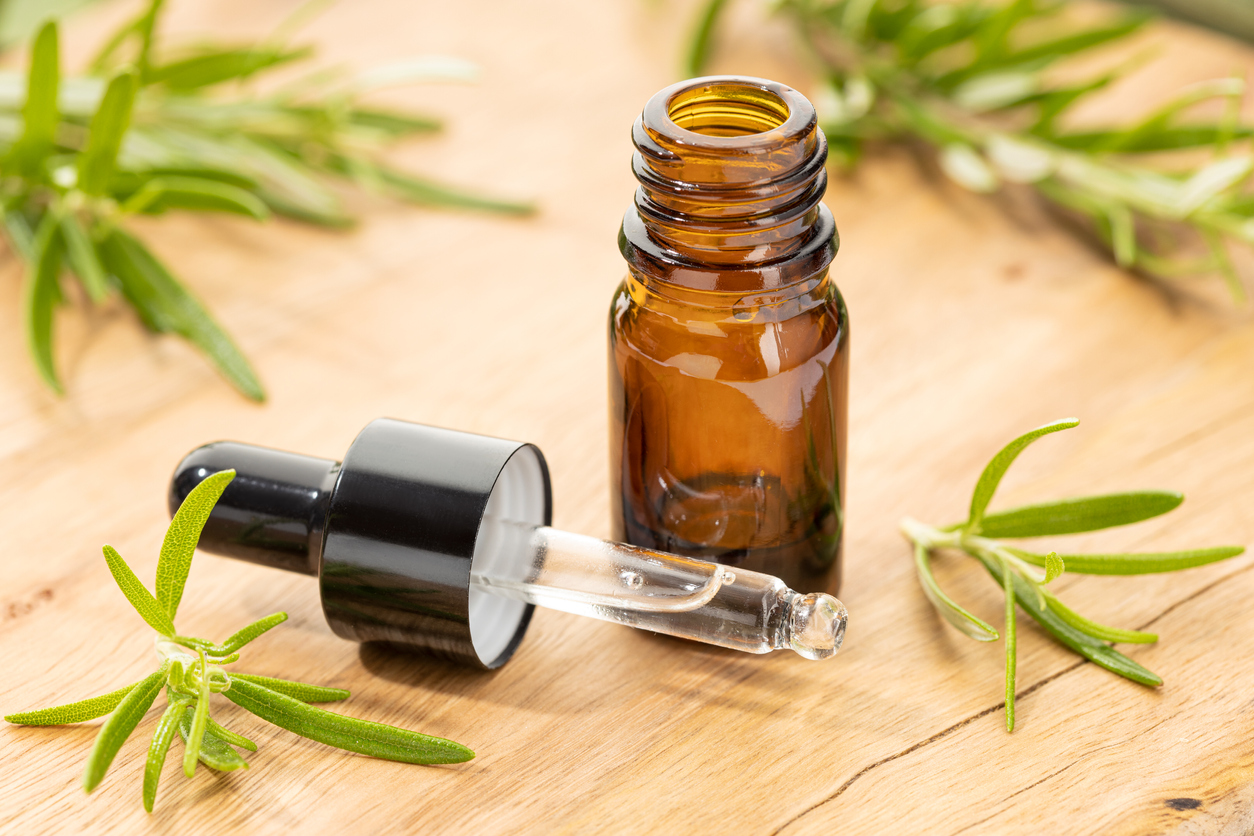 Rosemary essential oil on wooden table