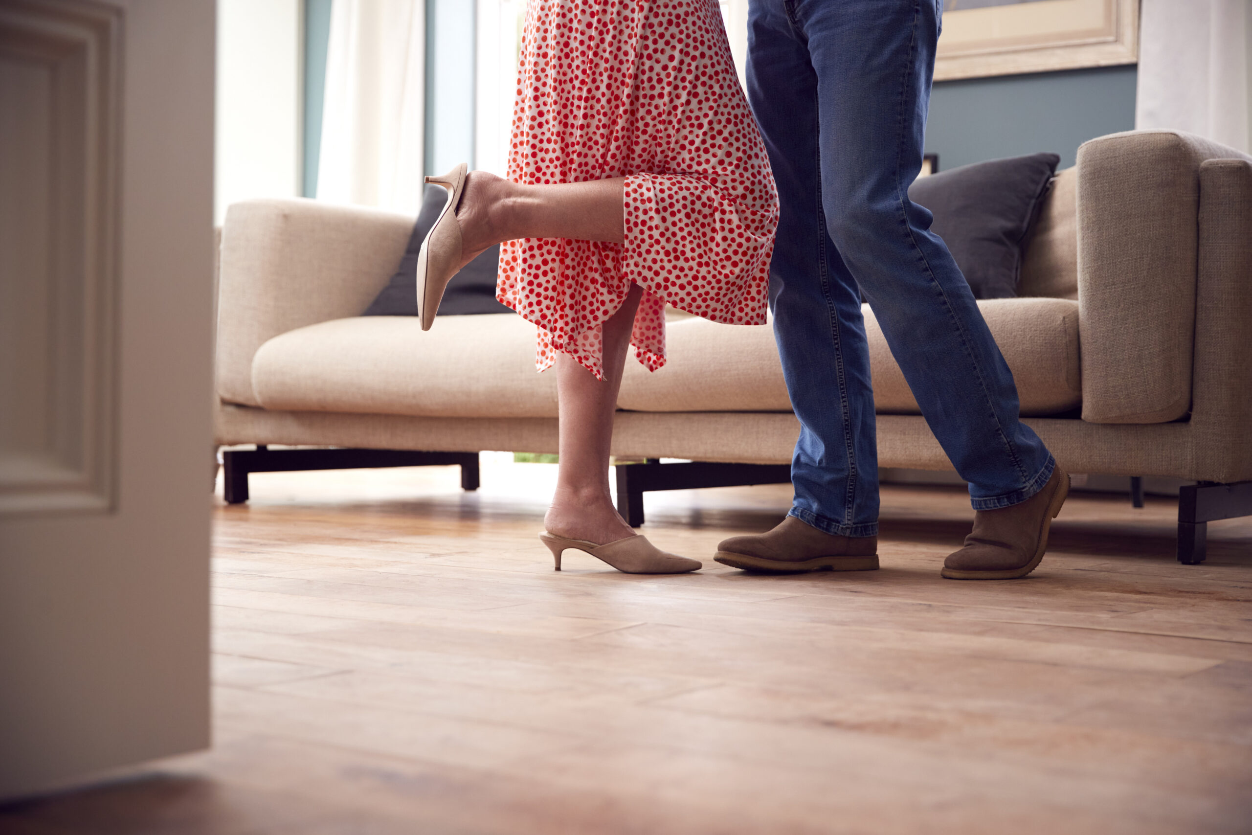 Close Up On Legs As Romantic Senior Retired Couple Dancing In Lounge At Home Together