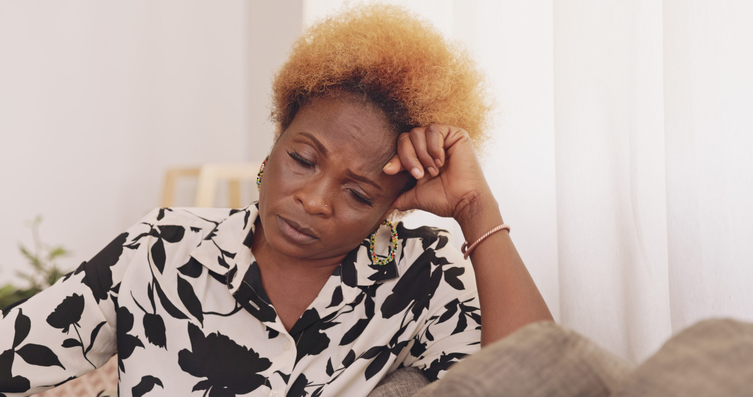 Shot of a mature woman being stressed on the couch at home