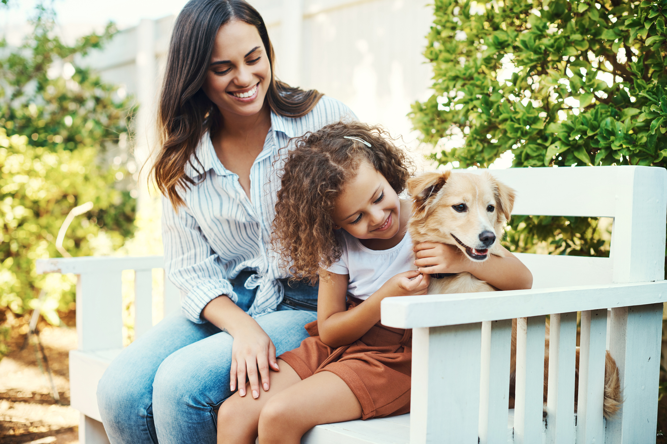 Shot of a mother and daughter spending time together with their dog