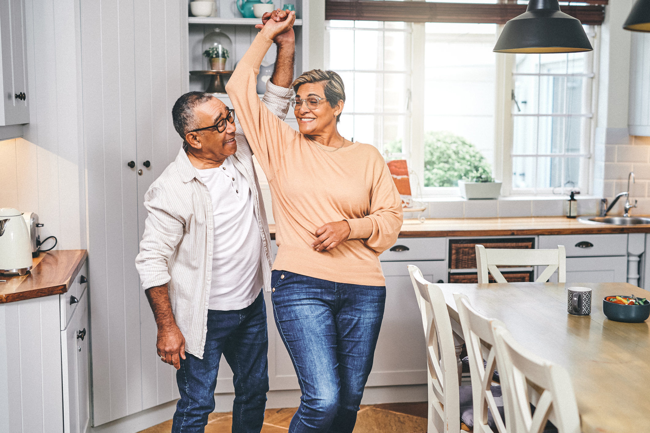 Shot of  a elderly couple dancing in the kitchen