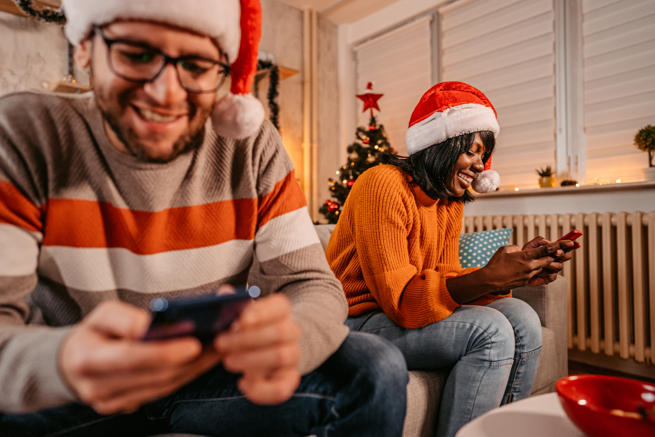 Couple looking at their phones at New year eve.