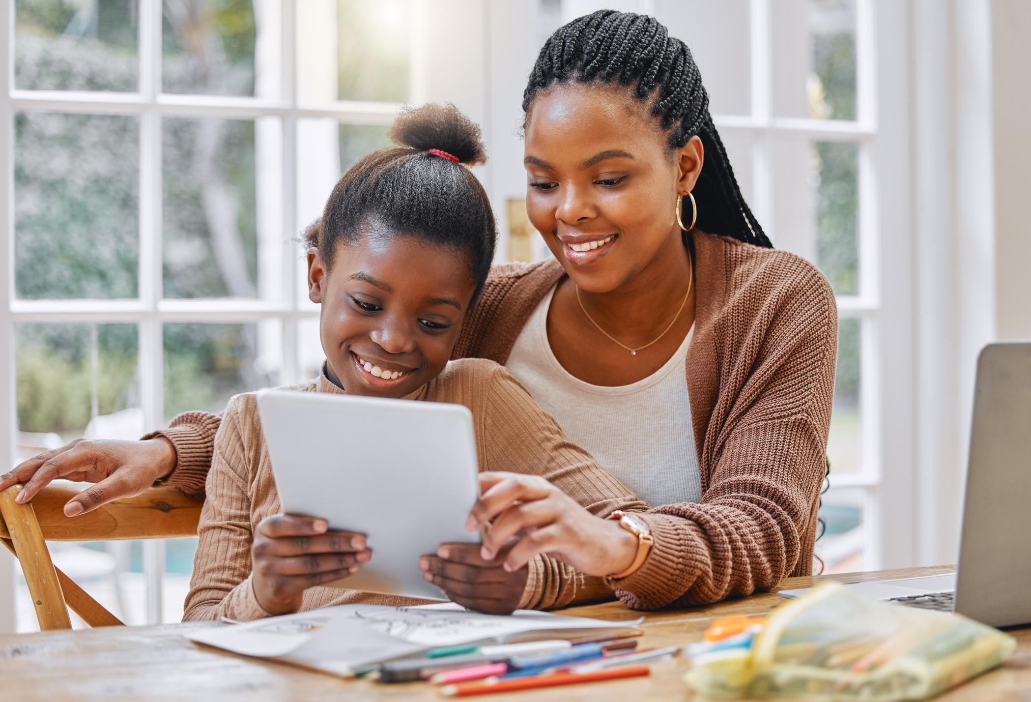 Shot of a young mother and daughter using a digital tablet at home