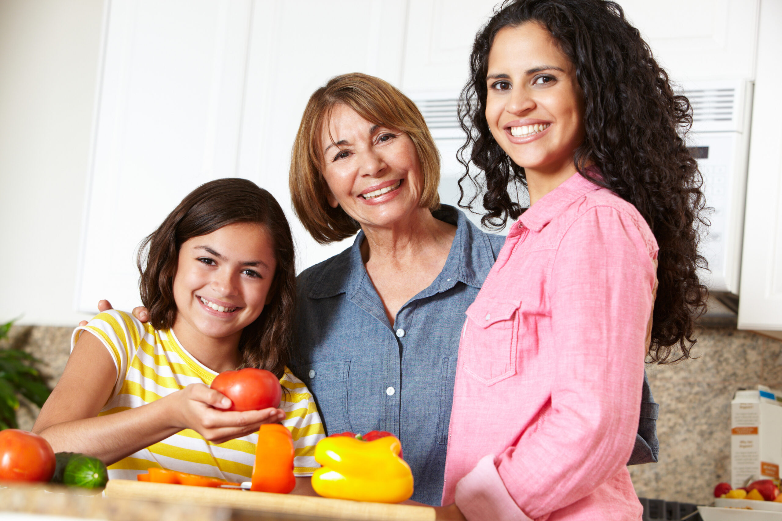 A lady with her daughter and mother preparing a meal