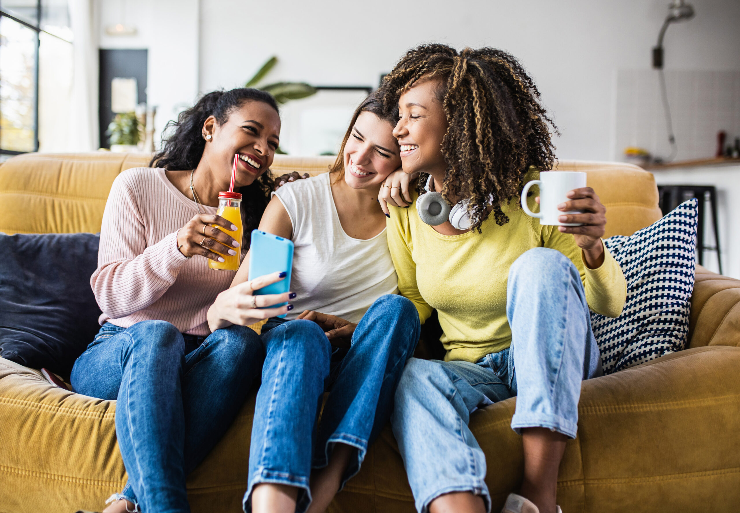 Cheerful multiracial female friends enjoying free time together at home