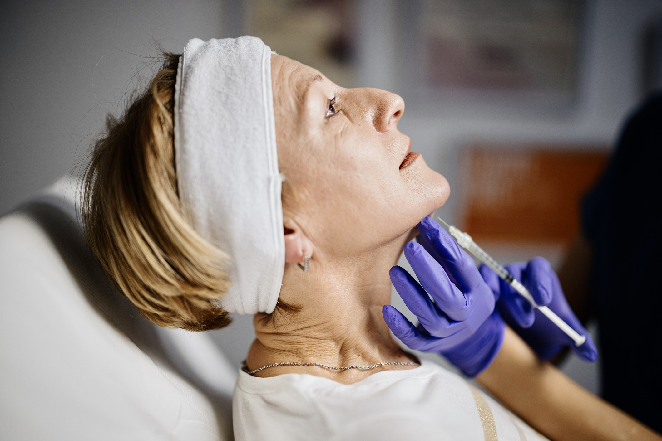 Female doctor giving patient lipolysis double chin treatment