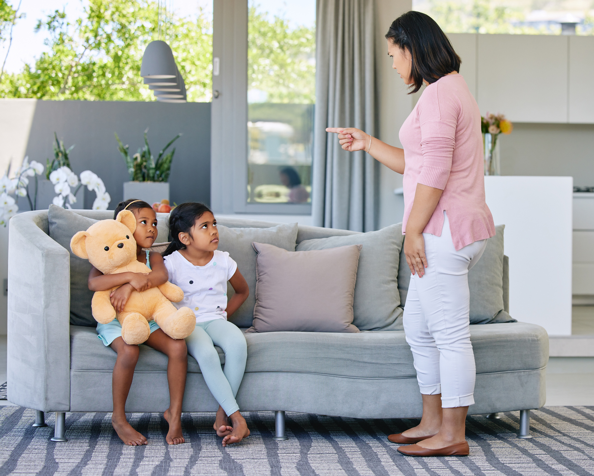 Shot of a young woman scolding her daughters