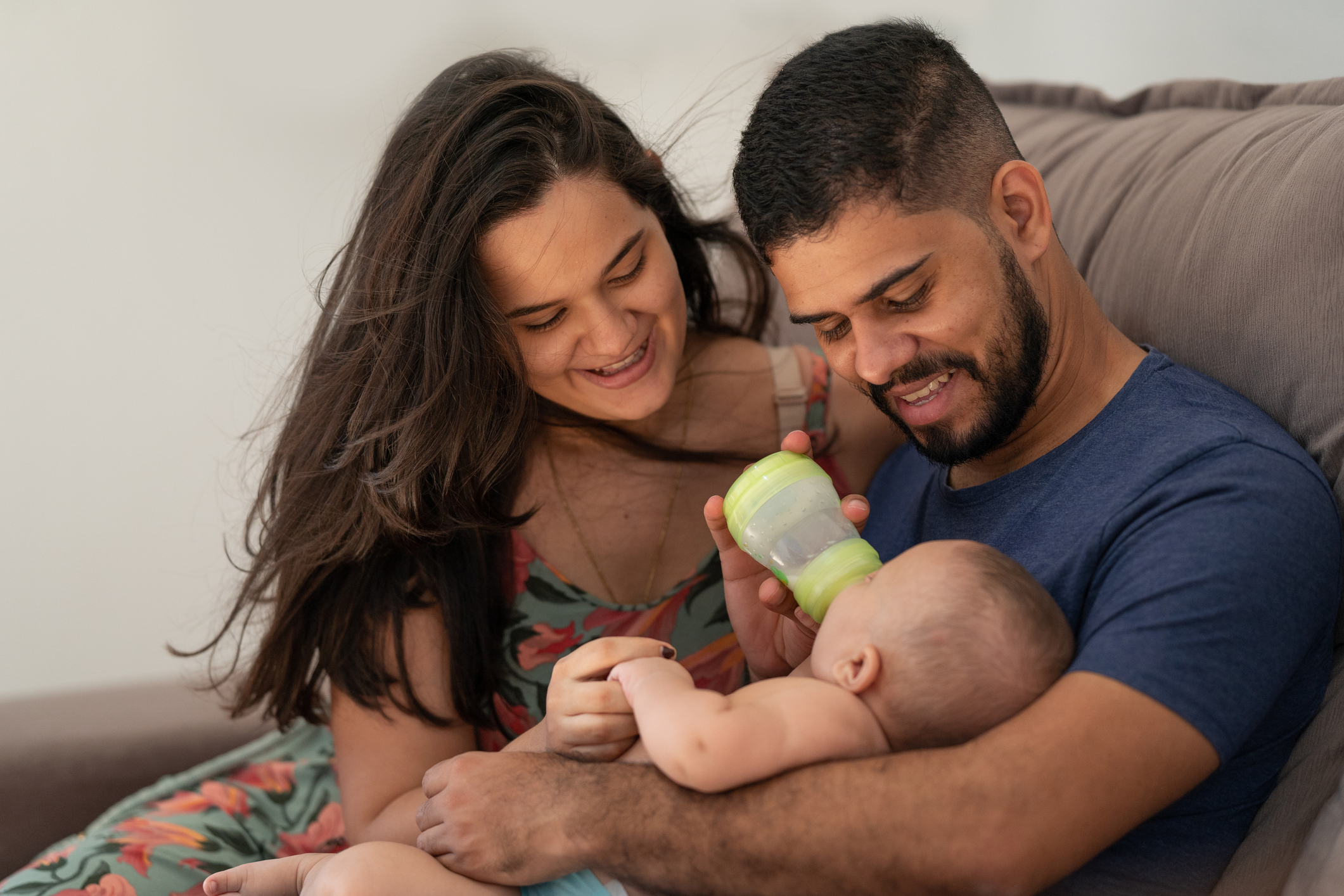 Baby drinking milk from a bottle on daddy's lap