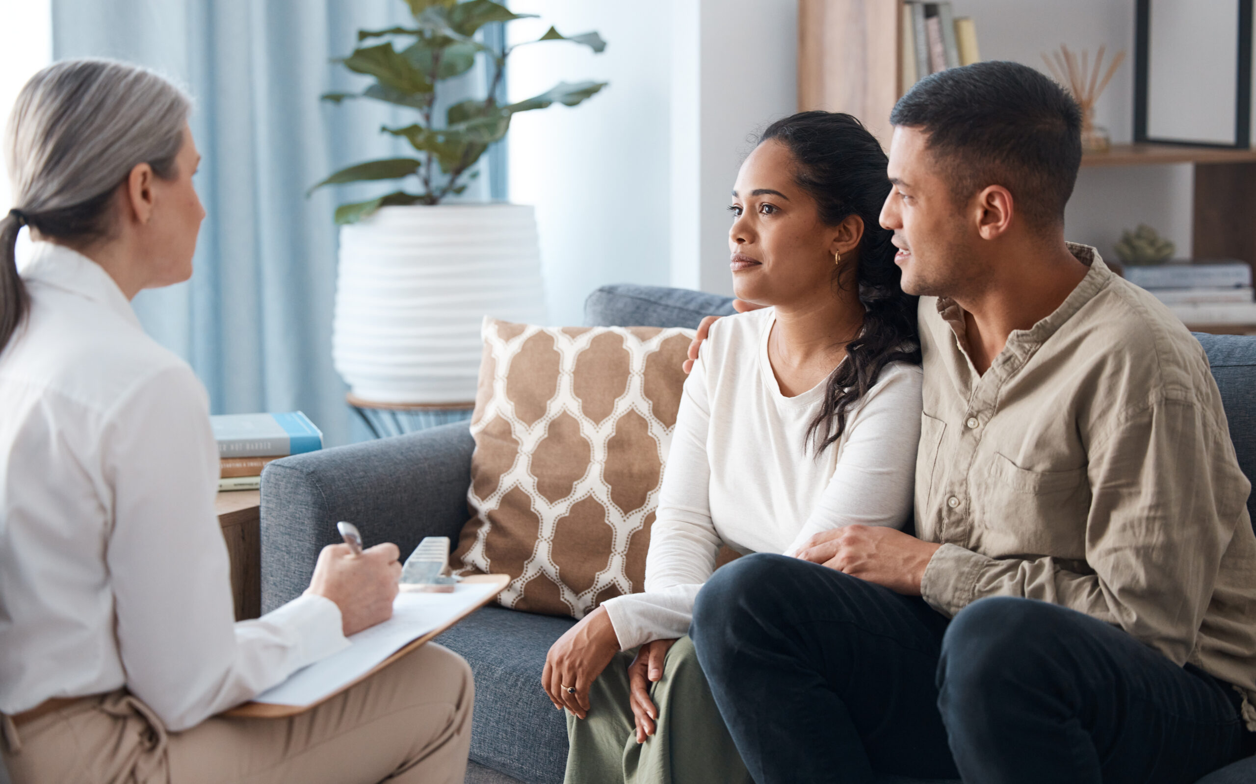 Shot of a happy young couple sitting together during a consultation with a psychologist