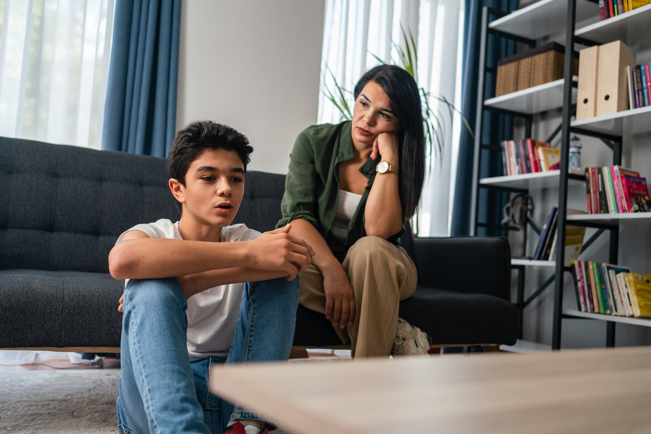 Mother and son sitting after quarrel at home