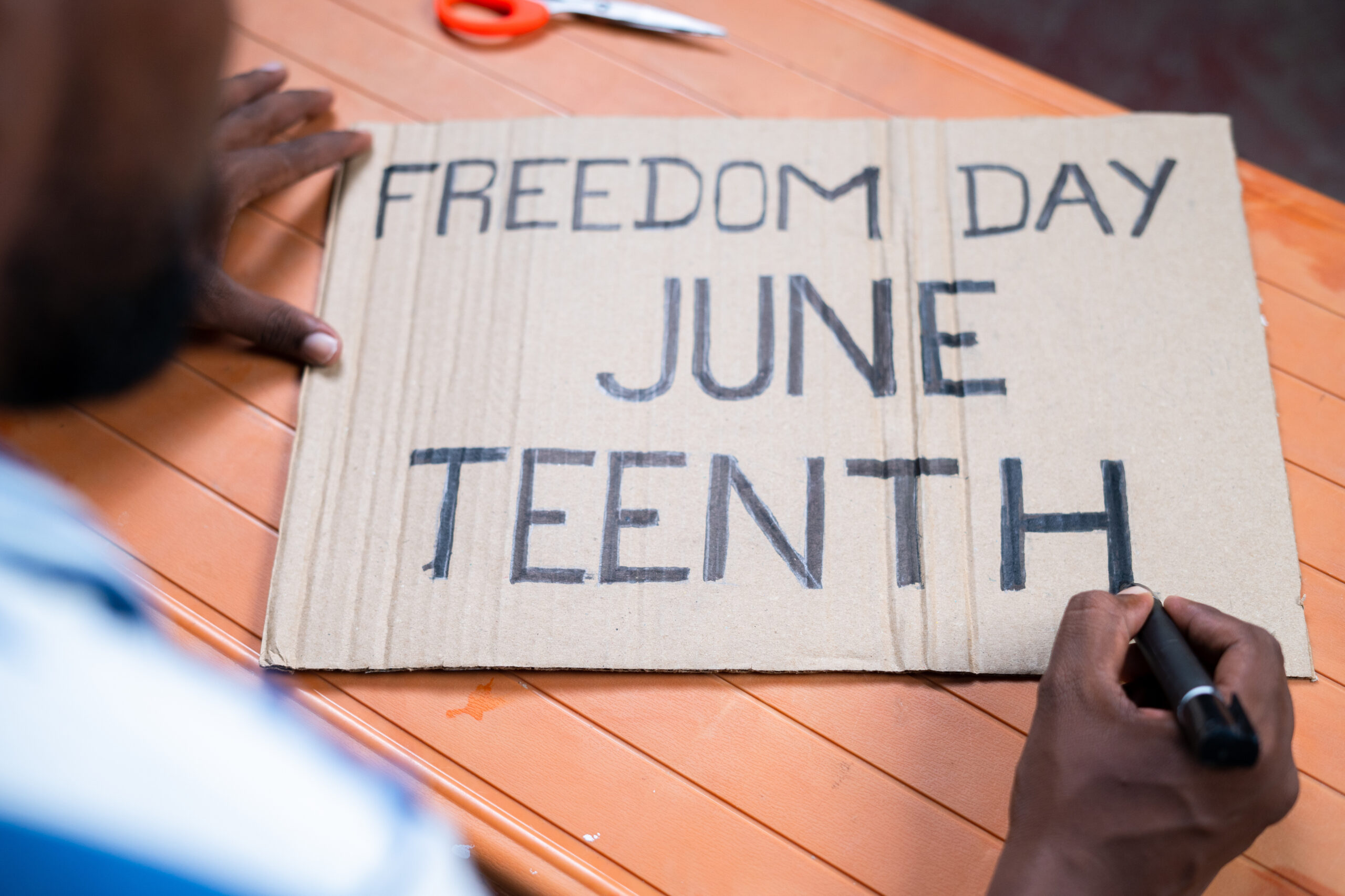 shoulder shot of activist preparing freedom day junteenth sign board for marching - concept of independence and campaign