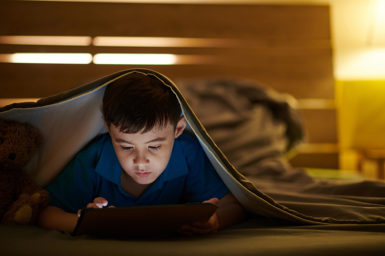 Preteen Boy Lying under Blanket