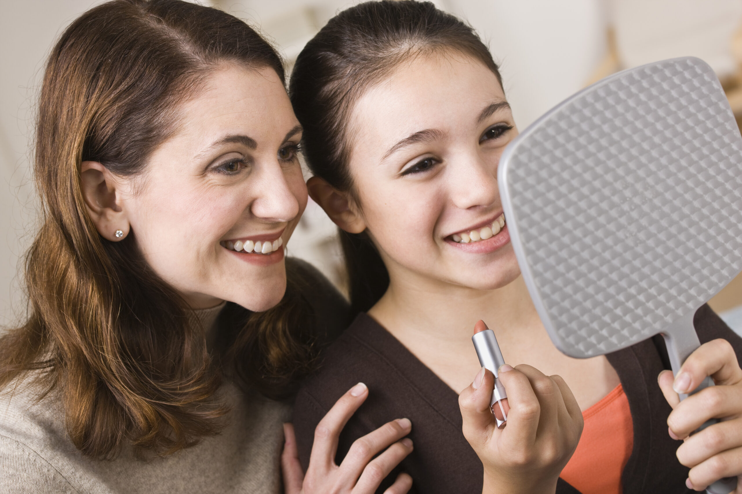 Smiling Mother and Daughter Looking into Mirror