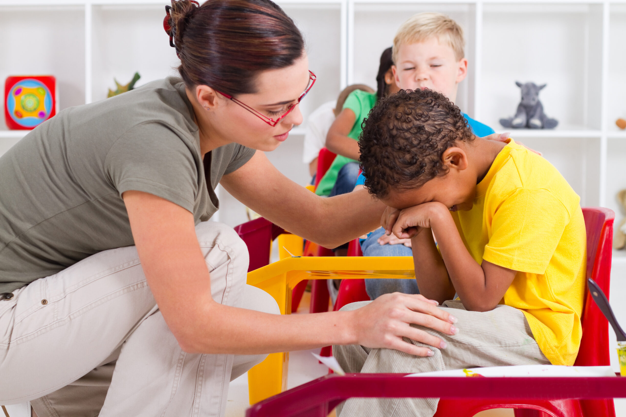 teacher comforting crying boy