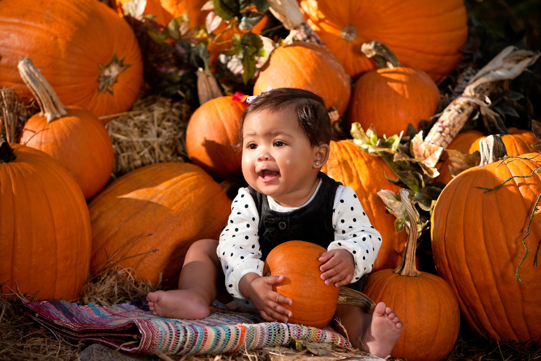 Baby girl holding a pumpkin