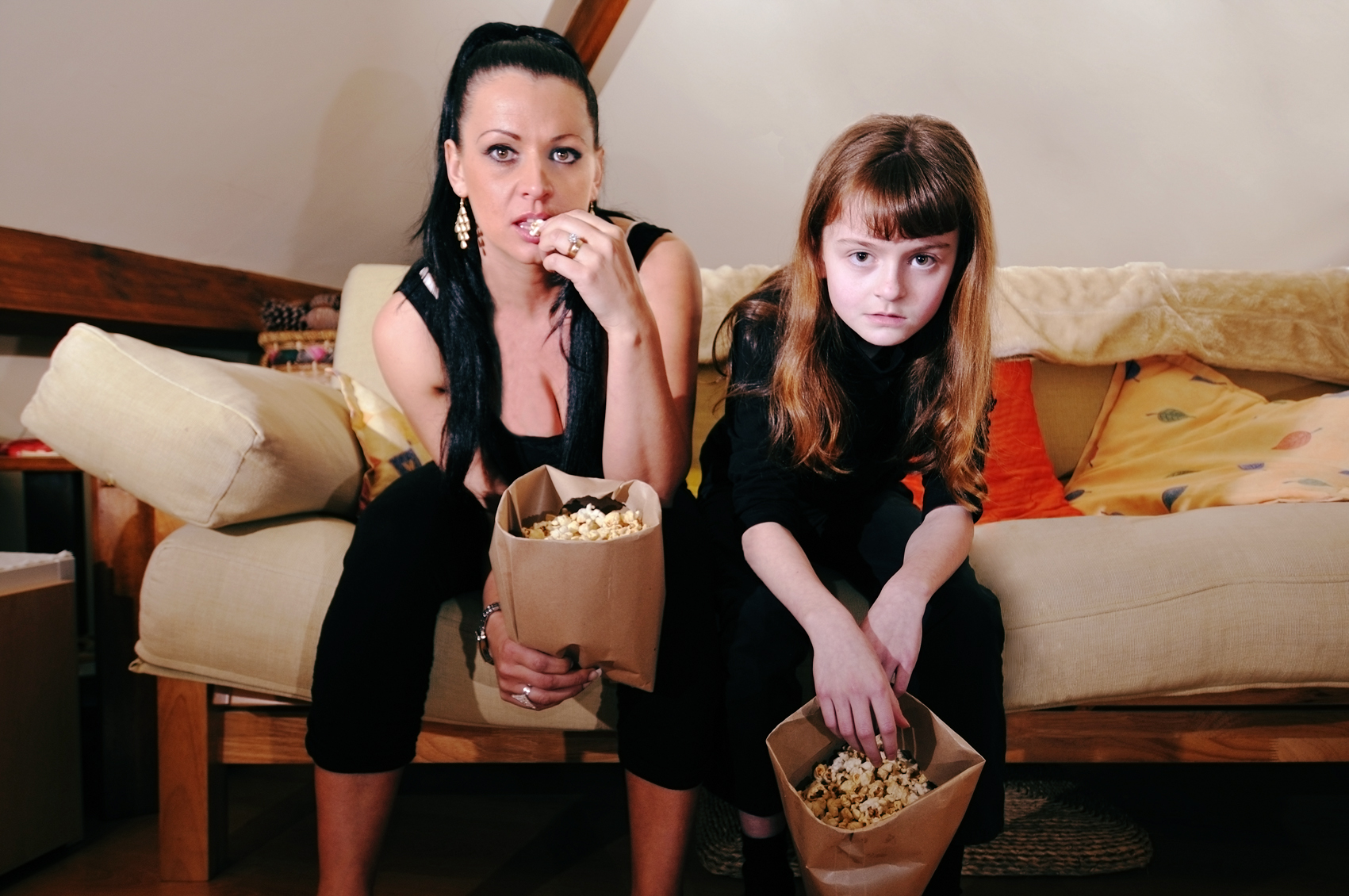 Slob mother and daughter pigging out on popcorn