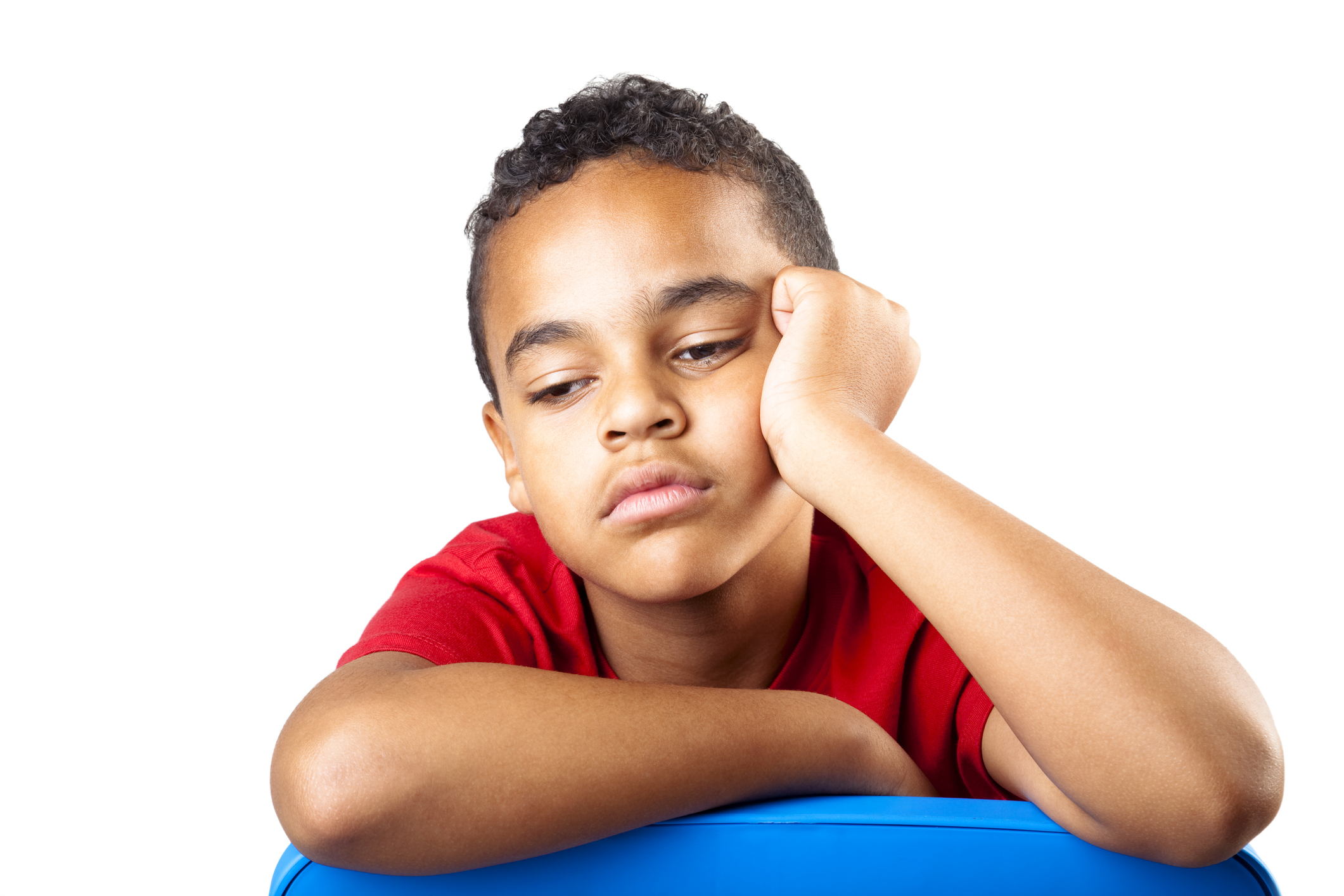 A young boy in a red shirt is bored and tired