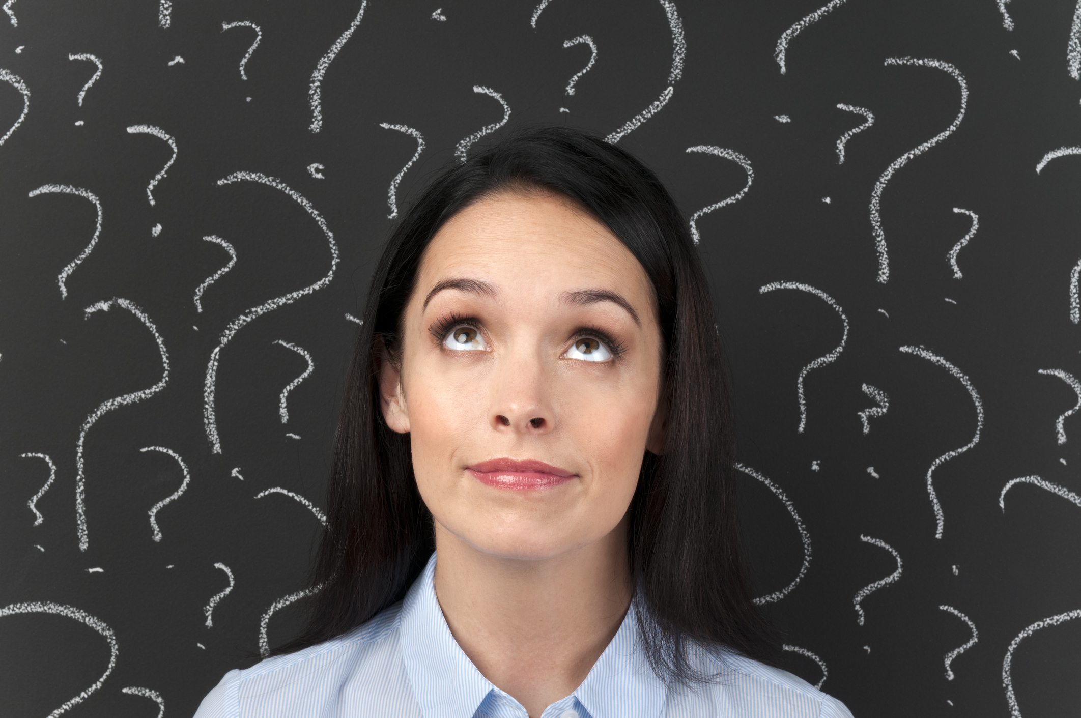 Woman with question marks on a blackboard