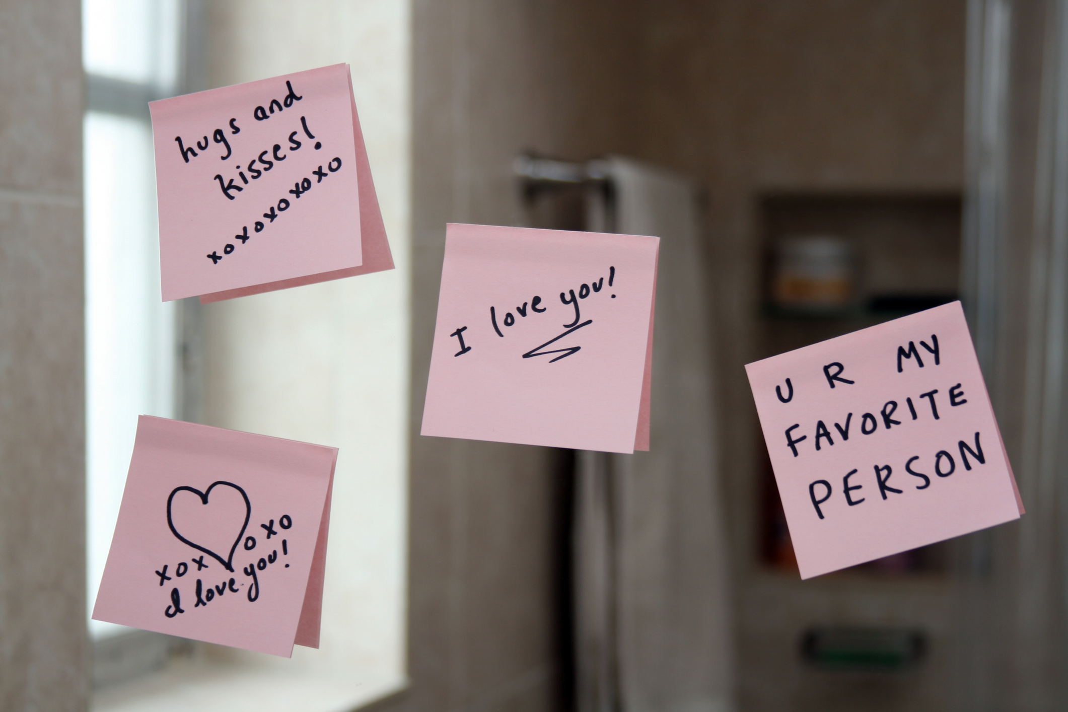 Love notes on sticky paper stuck up on a mirror