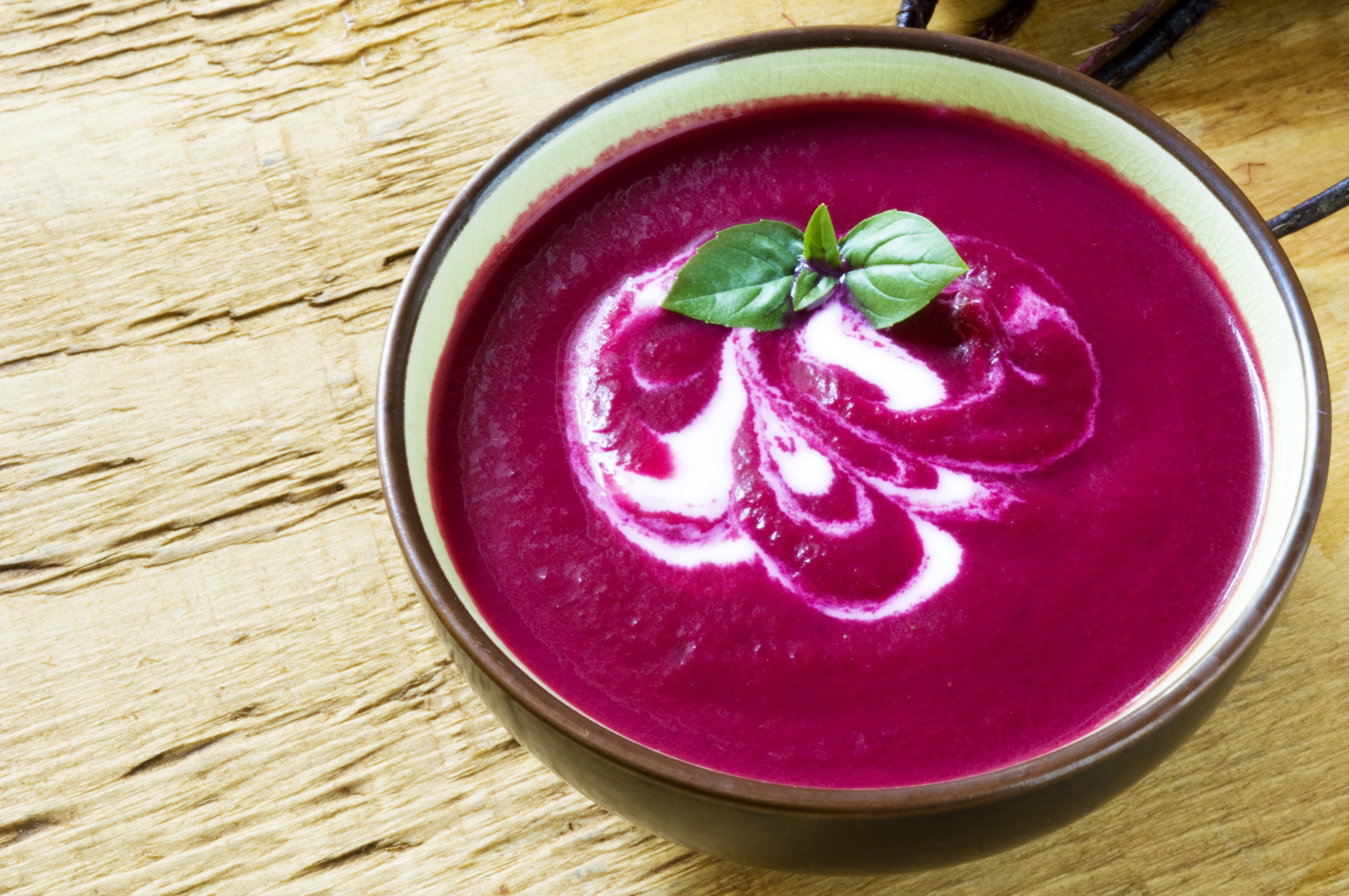 Violet colored beet soup in bowl on the counter