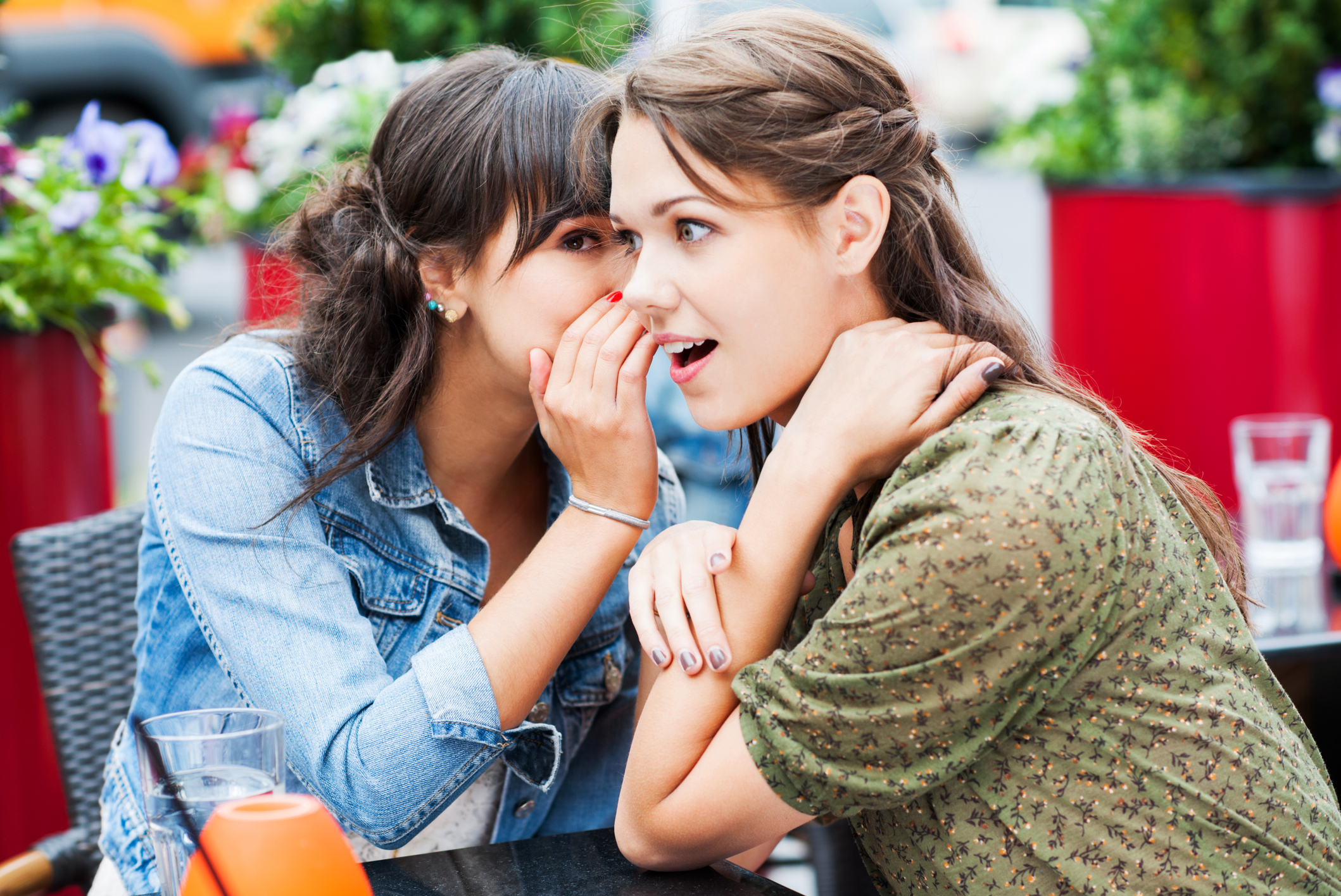 Two best friends sitting in a cafe and gossiping,