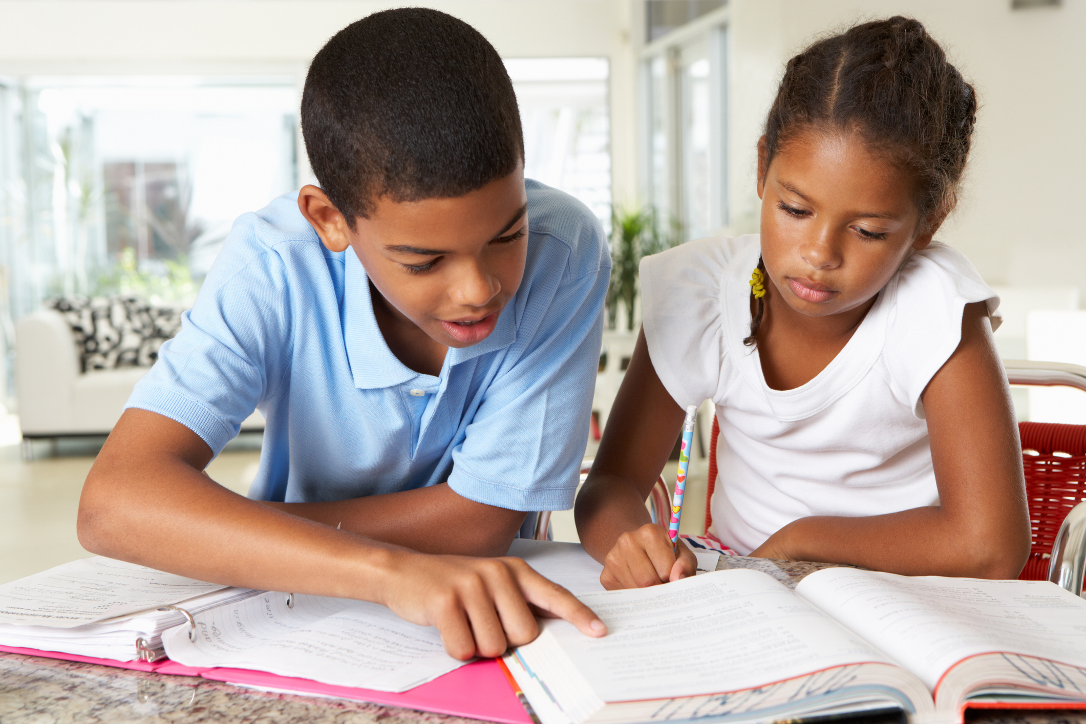 Boy and girl doing homework in kitchen