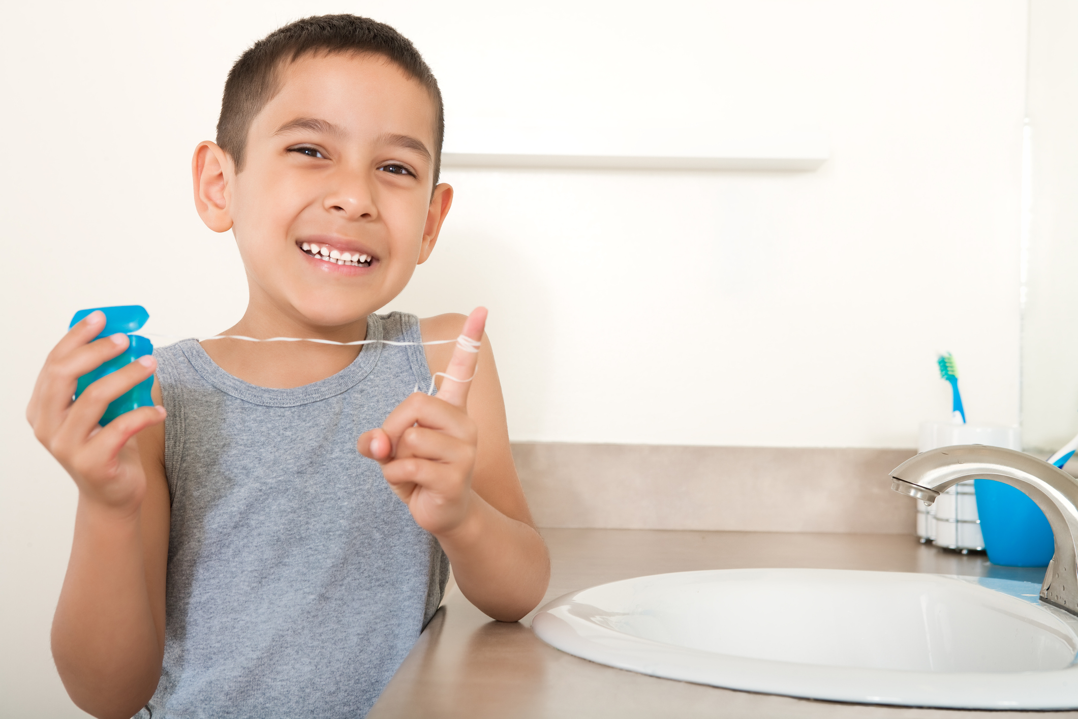 Smiling boy flossing