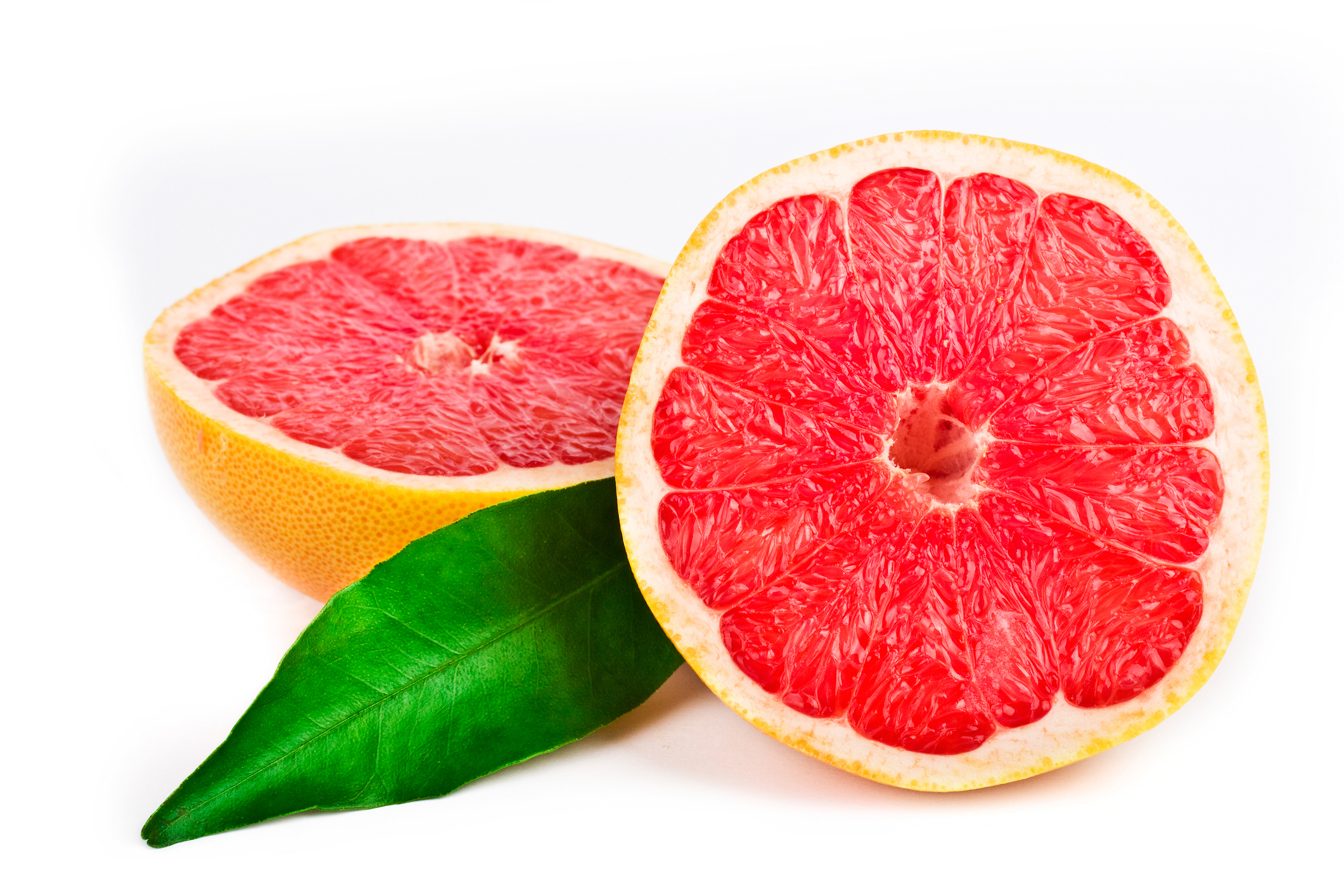 Pink grapefruit cut in half with a green leaf