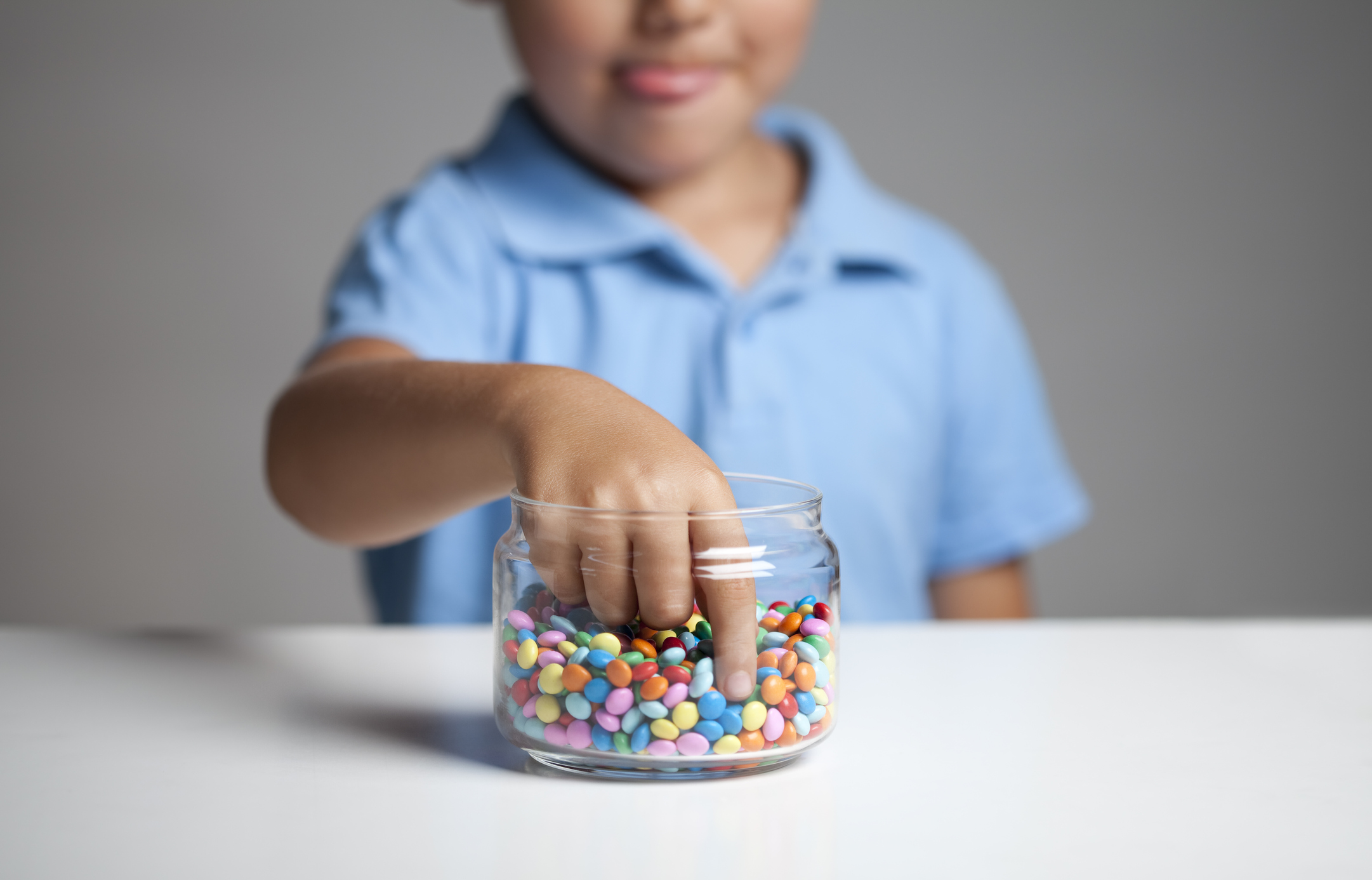 Little boy taking candy from jar