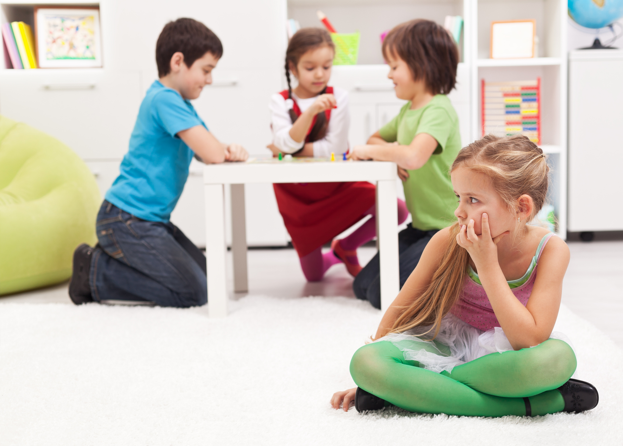 Little girl sitting apart - feeling excluded by the others