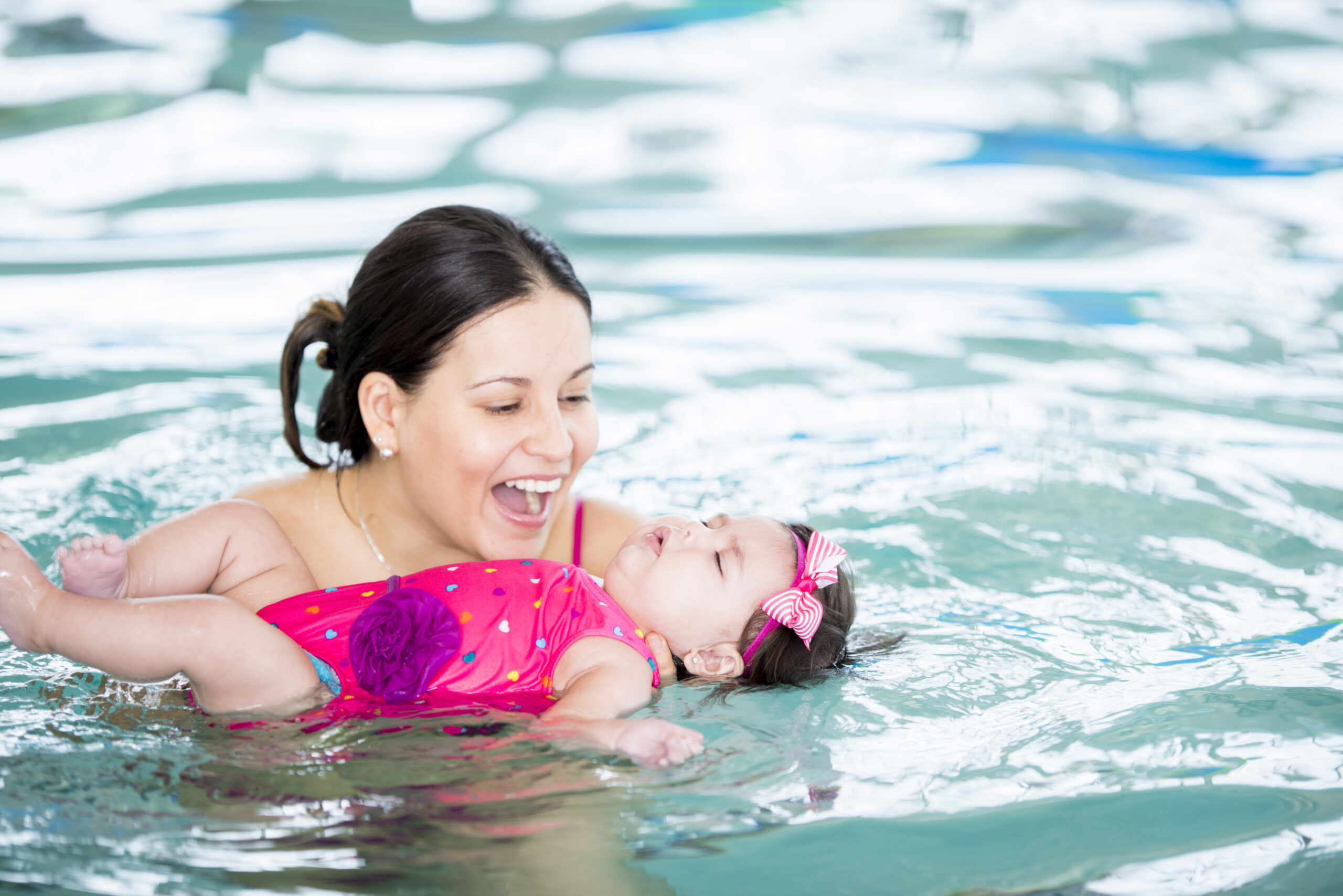 Mother holding baby in swimming pool