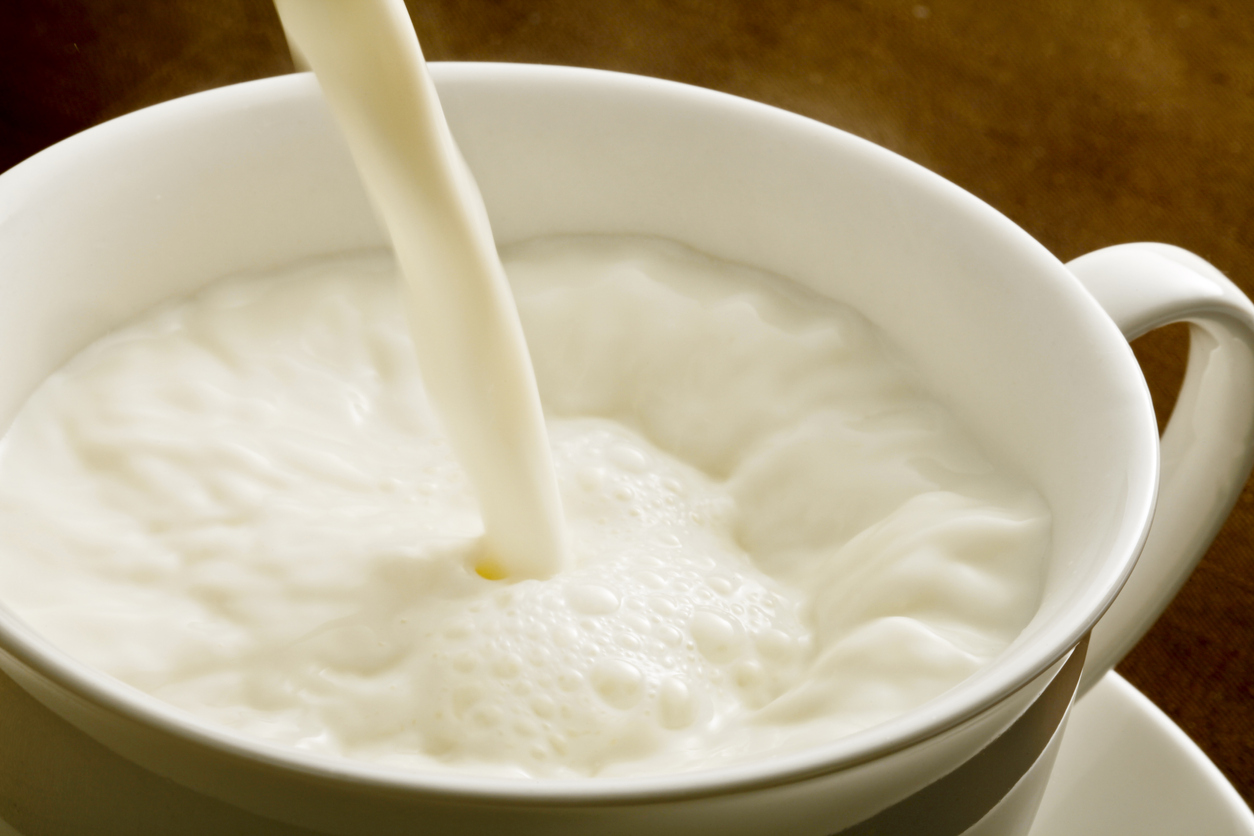 Hot milk being poured in a cup