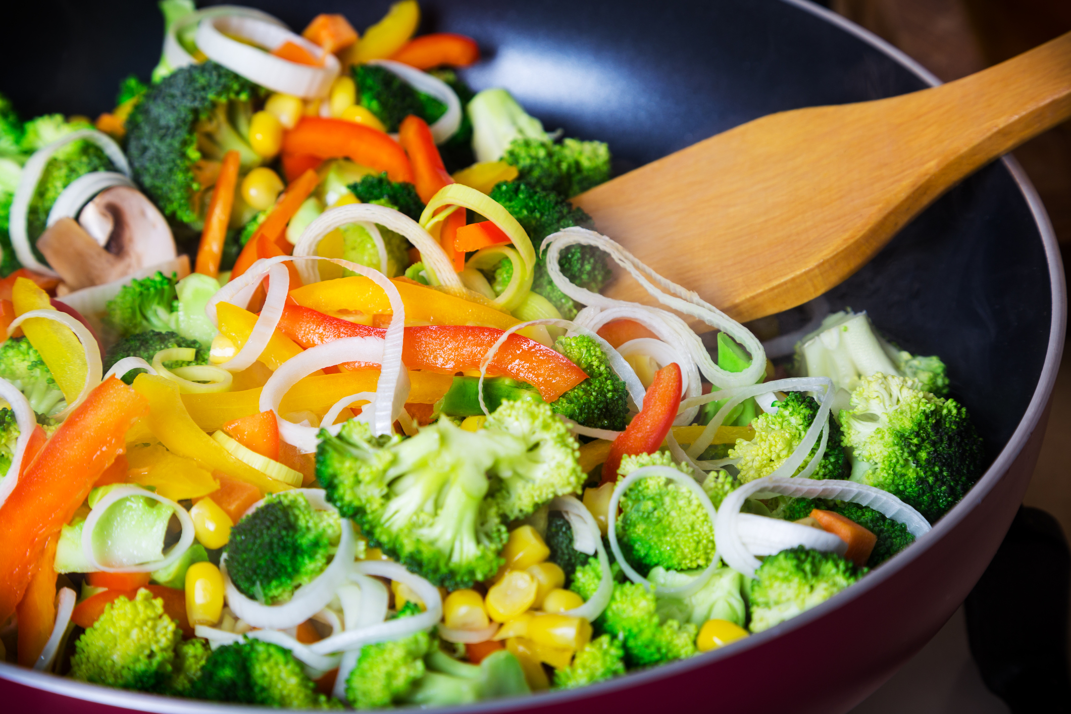 frying vegetables in pan with spatula