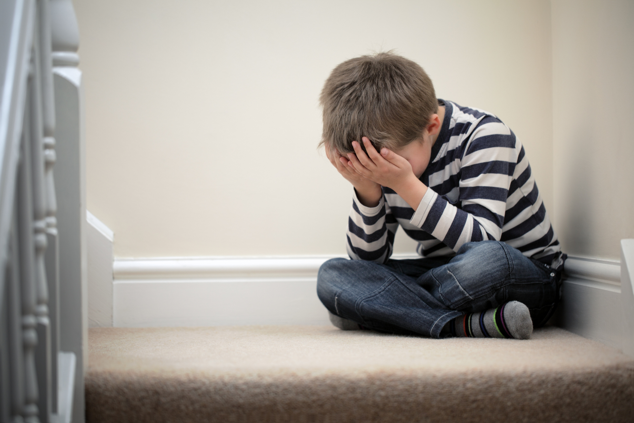 Upset problem child sitting on staircase