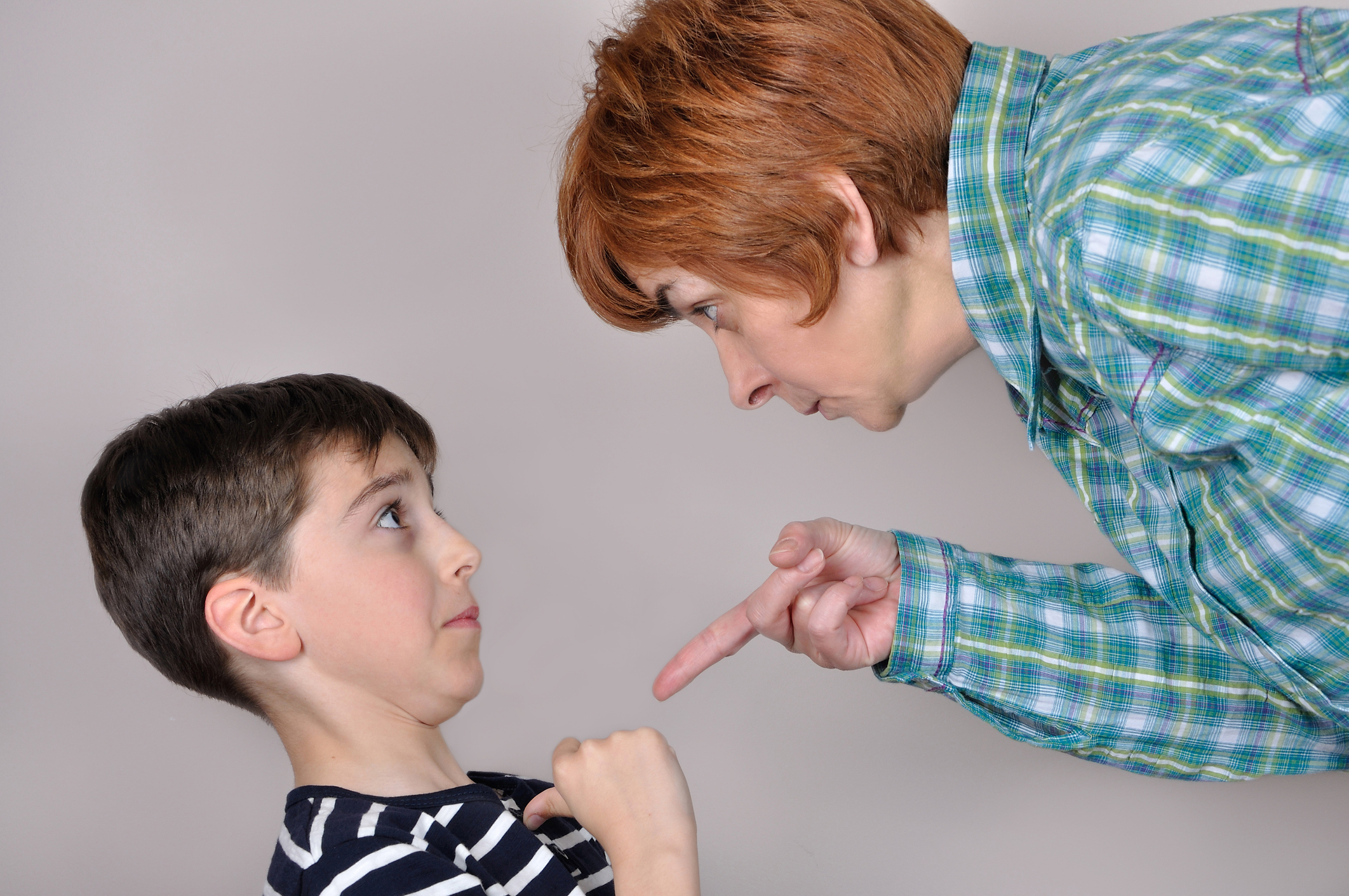 Woman scolding a scared young boy