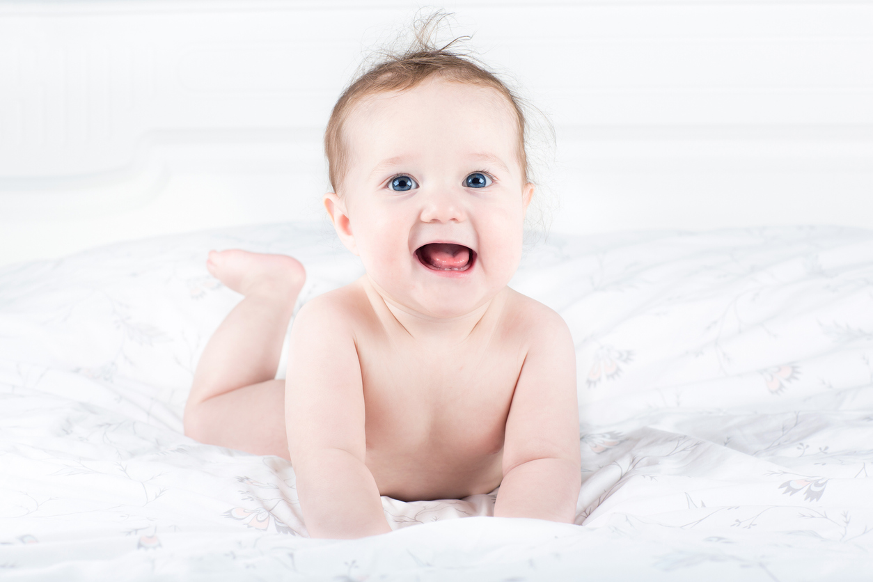 Sweet little baby enjoying her tummy time wearing diaper