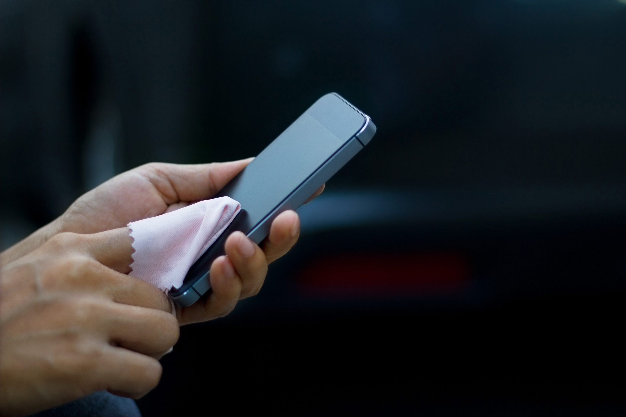 woman cleaning mobile smart phone with fabric