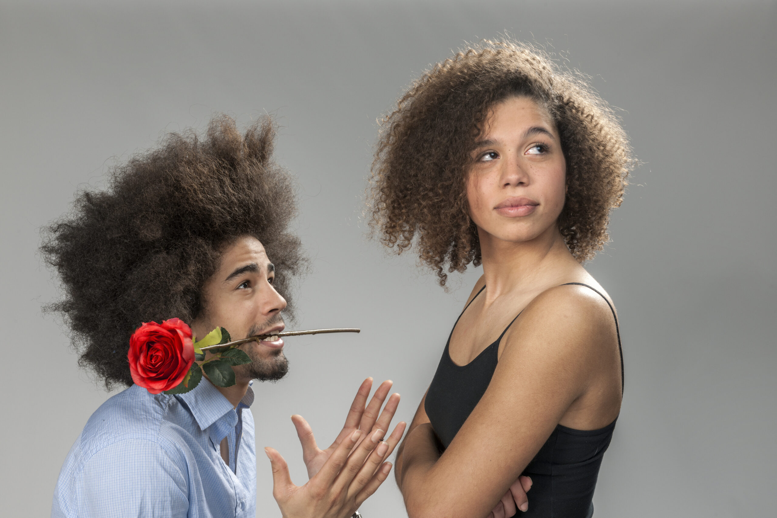 man begging woman for forgiveness, holding a rose