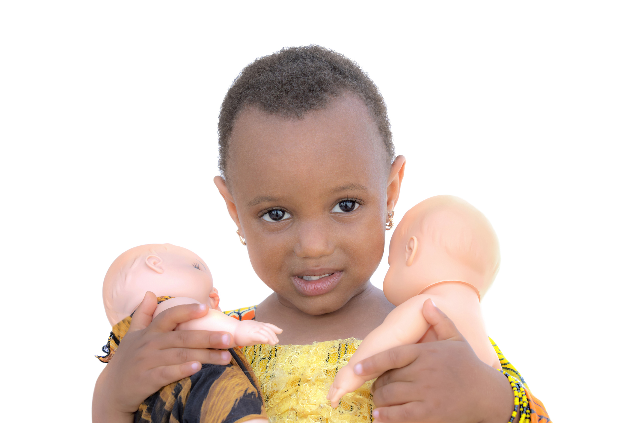 Three-year-old little girl holding two dolls, isolated