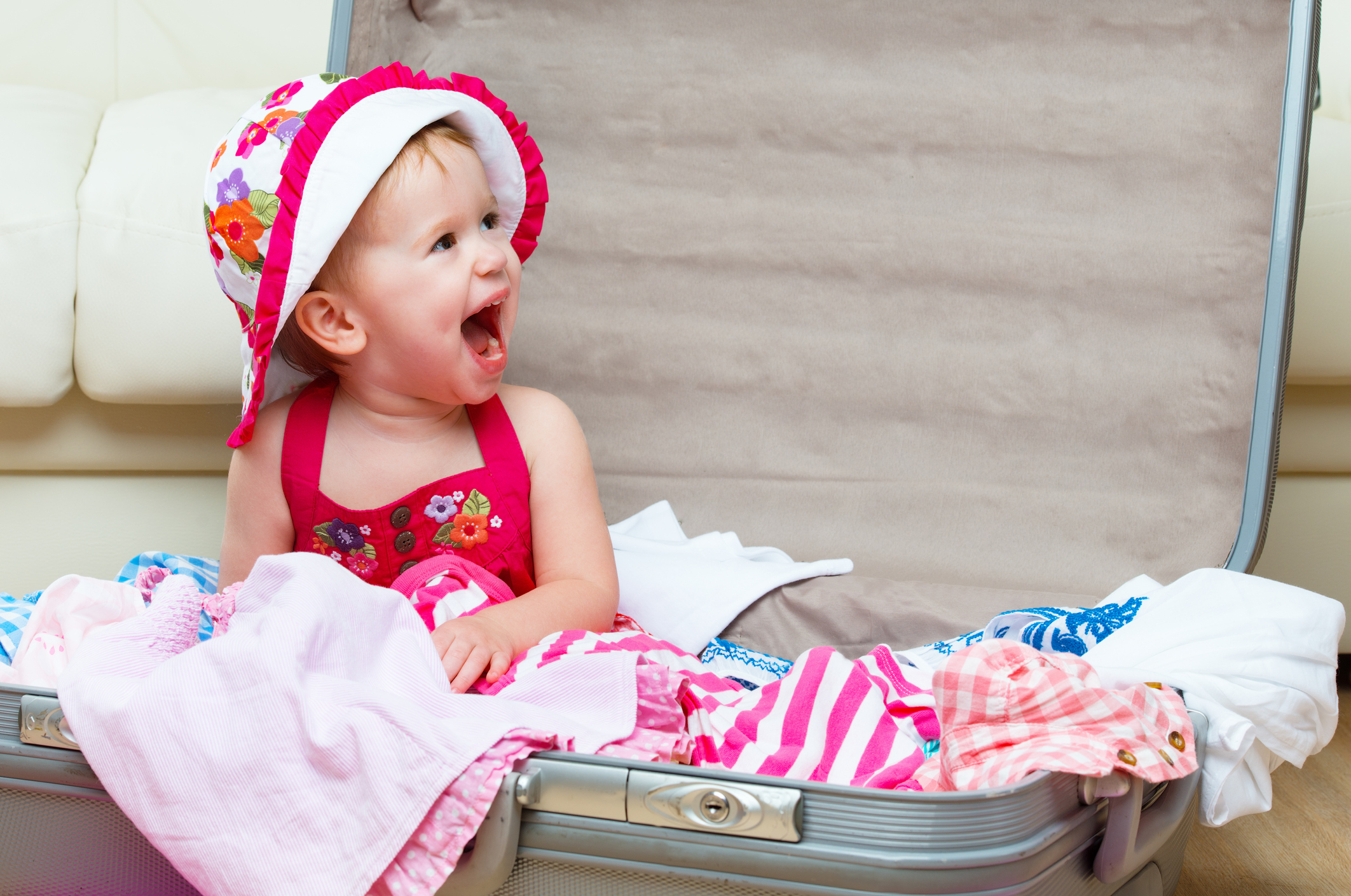 happy baby girl is going on trip, pack suitcase