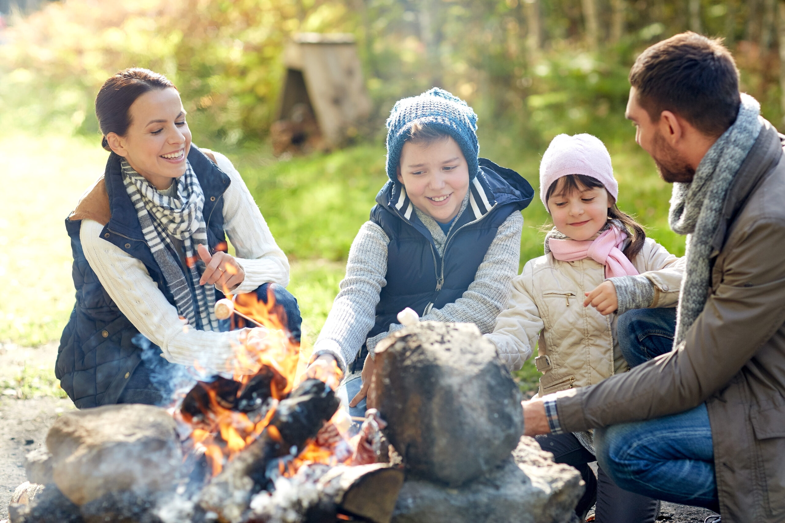 happy family roasting marshmallow over campfire