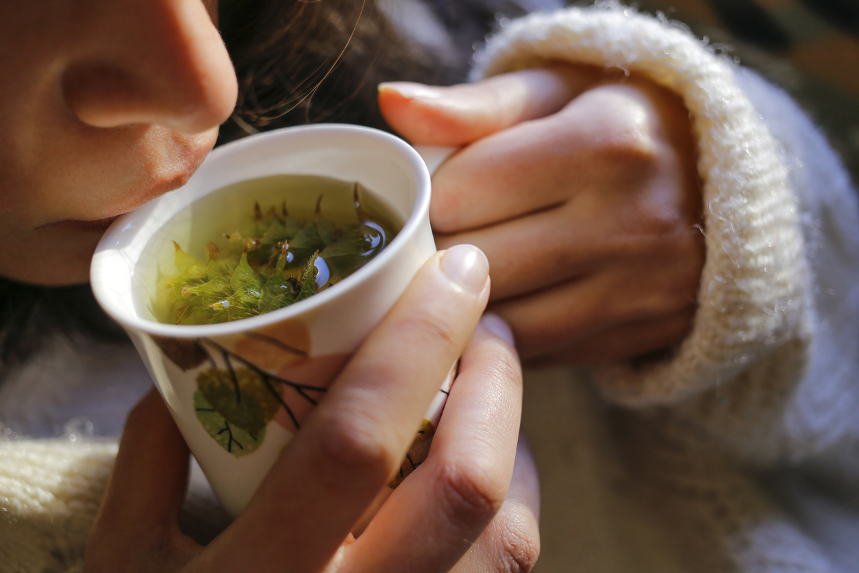 Sage tea with woman hand and woman lips