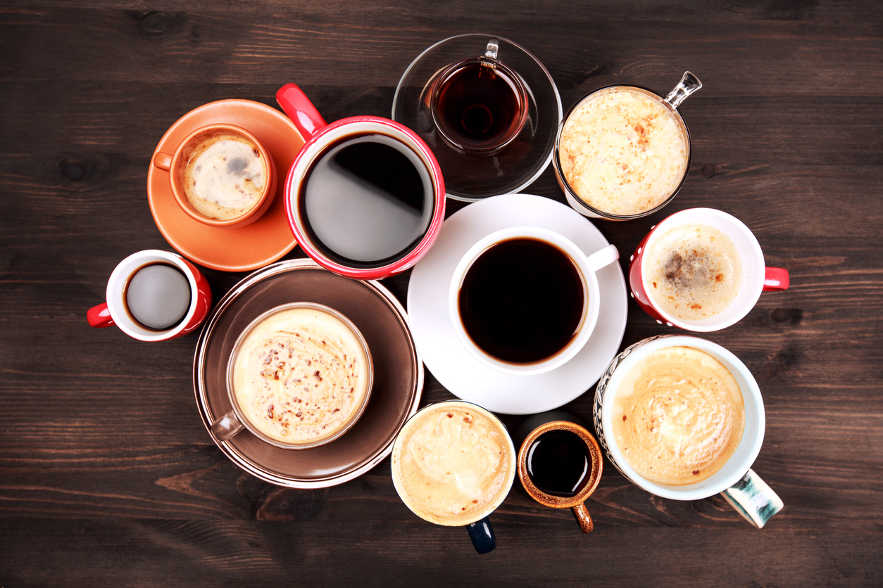 Many cups of coffee on wooden table