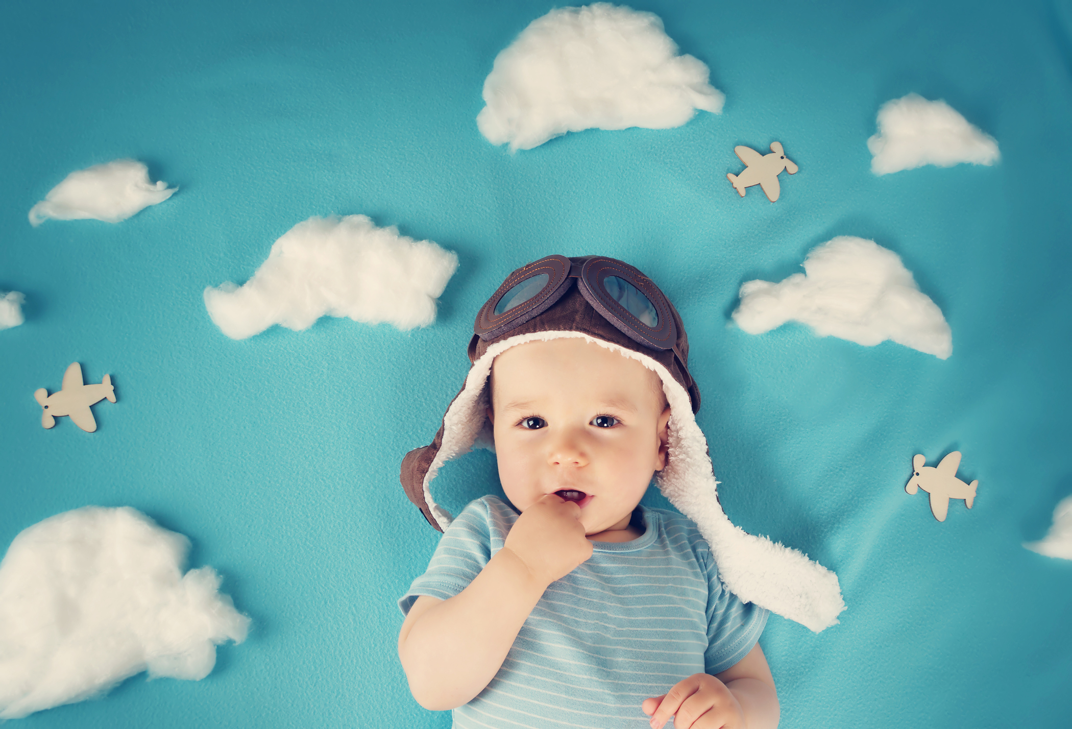 boy lying on blanket with white clouds