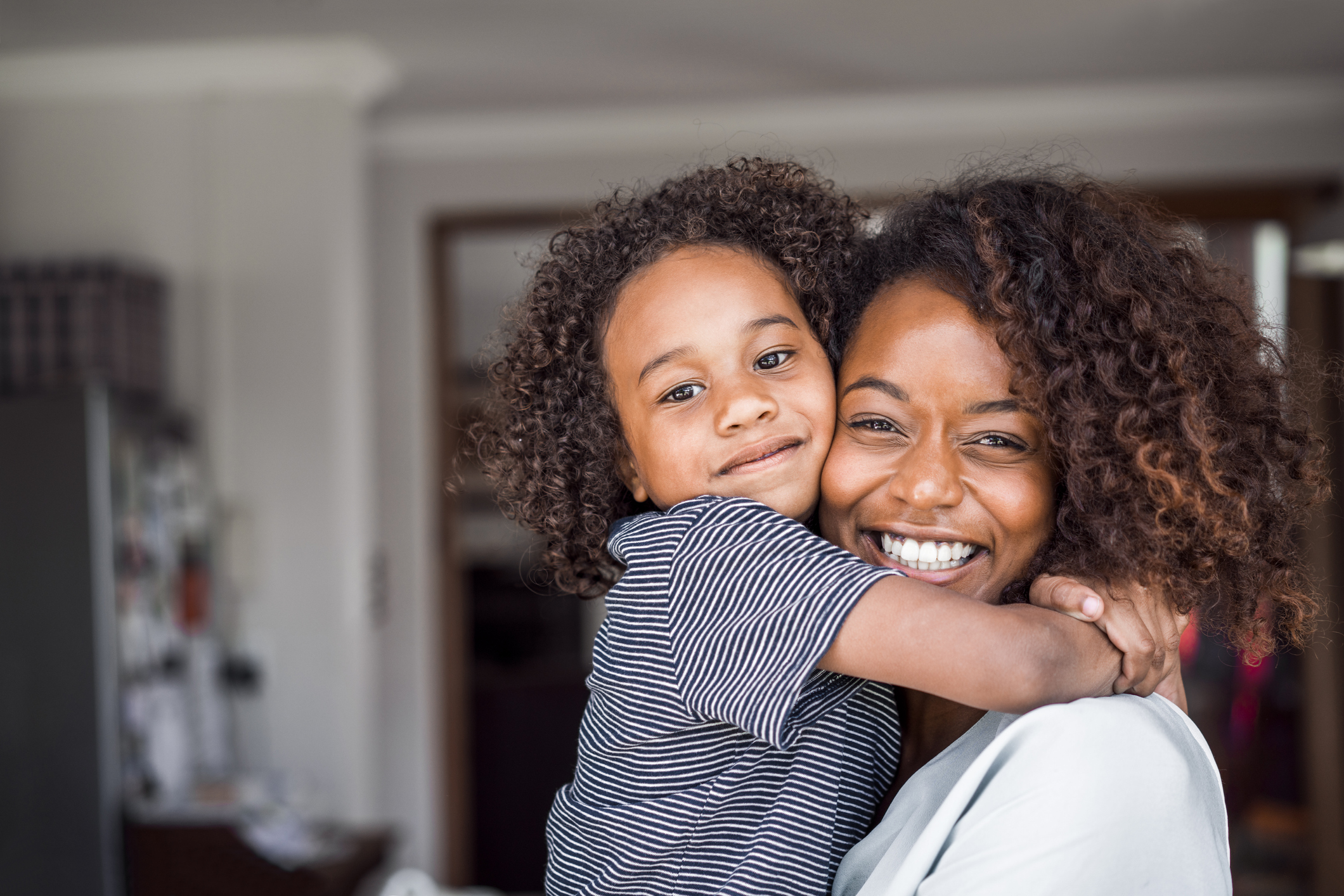 Happy mother and daughter embracing at home