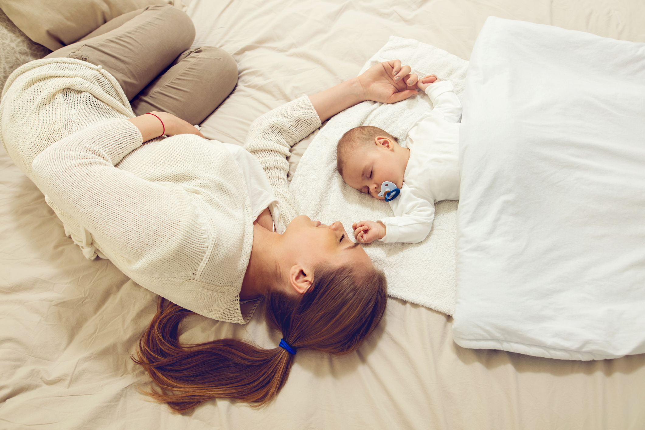 Mother and baby sleeping on the bed.