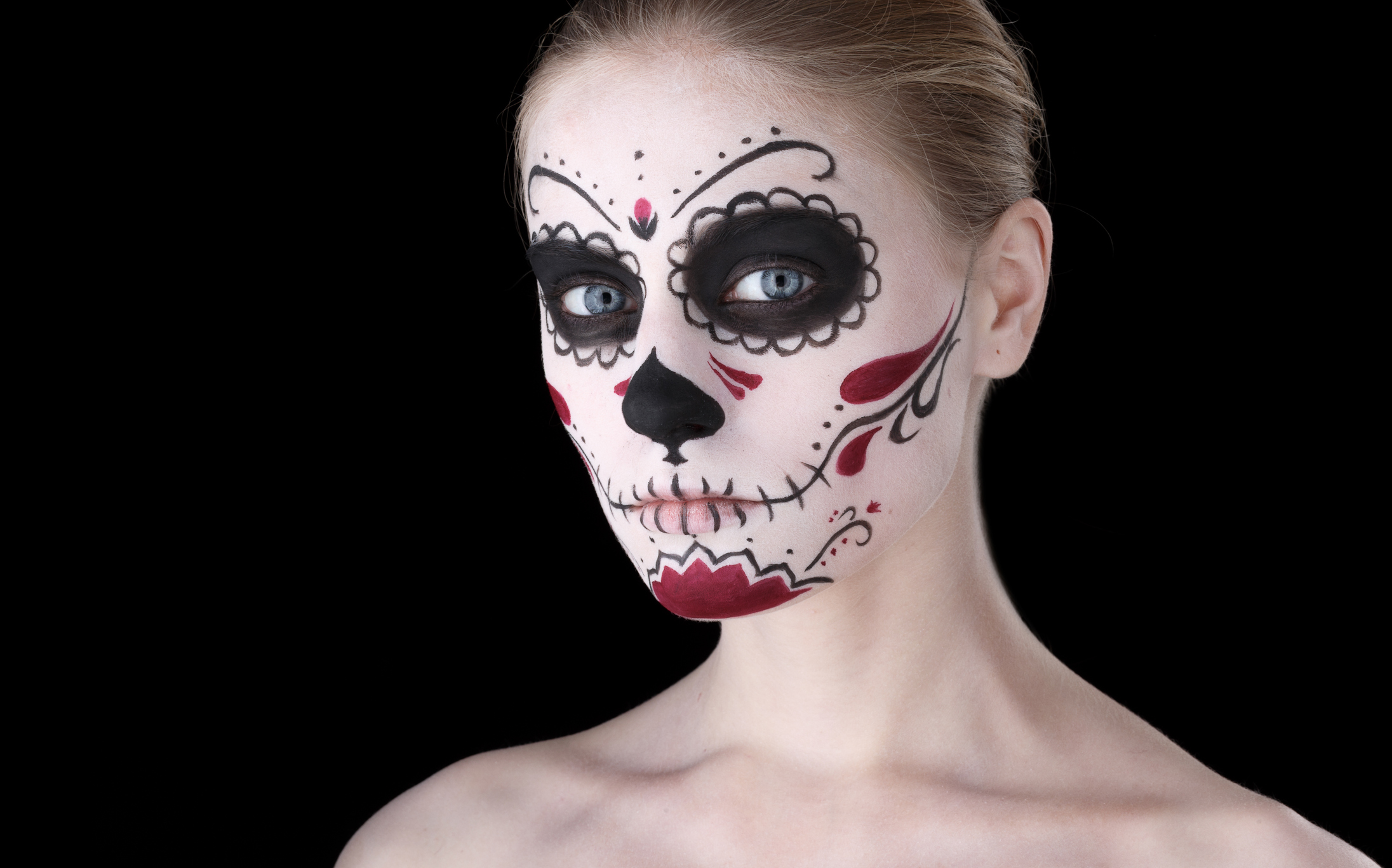 Woman with dia de los muertos makeup, black empty space.