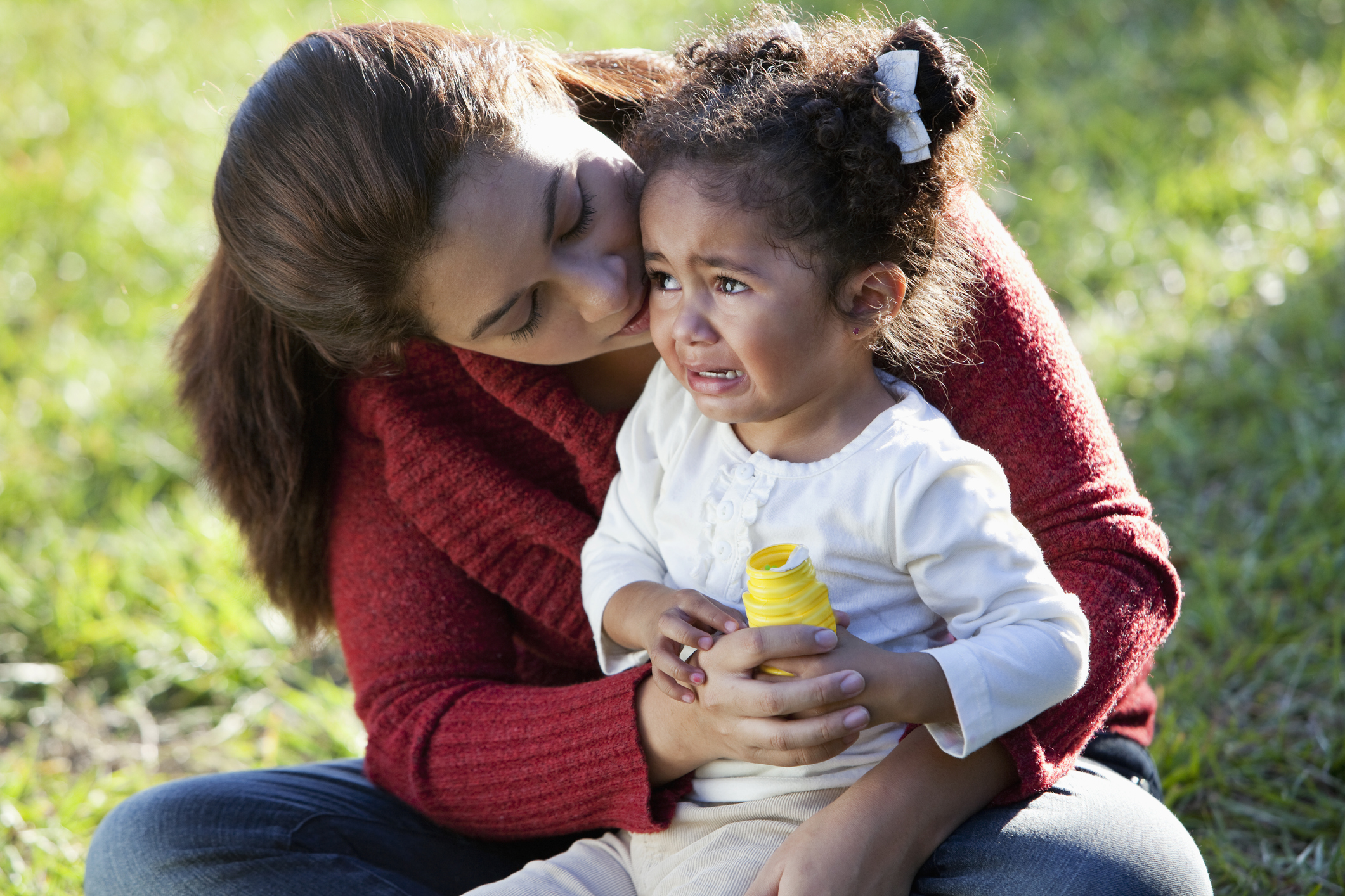 Hispanic mother comforting crying daughter