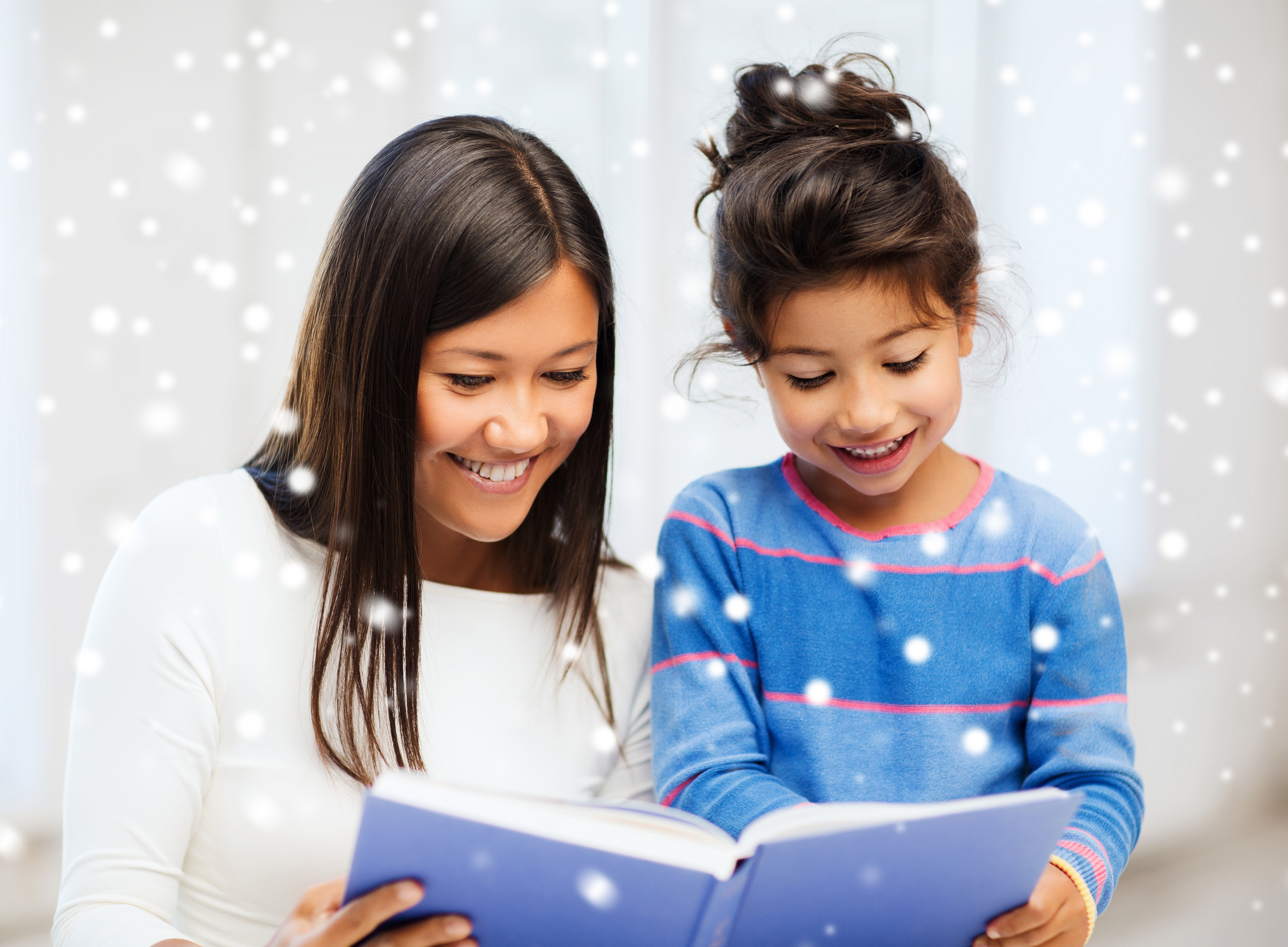 mother and daughter with book indoors