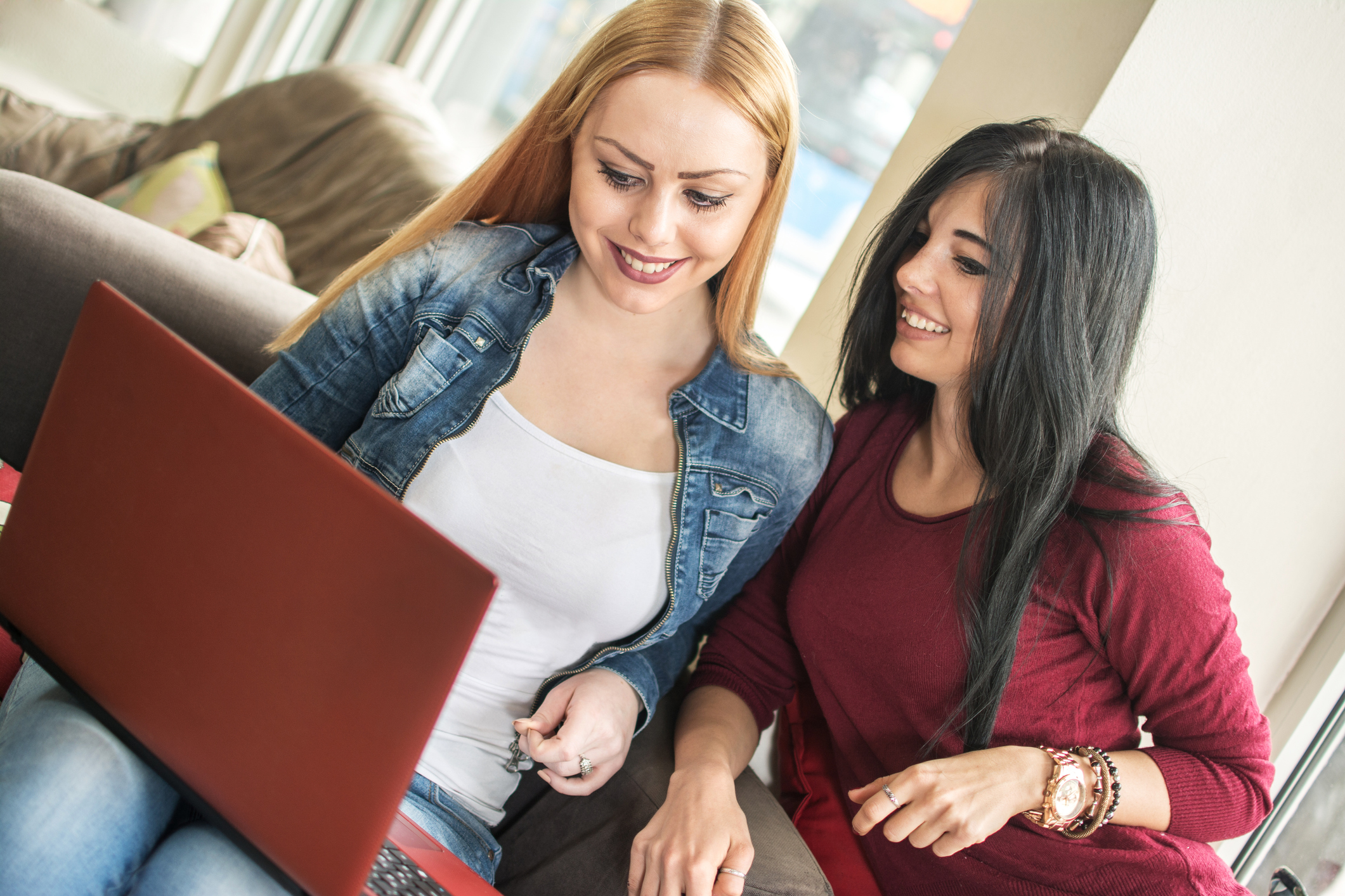 Two beautiful female friends browsing internet.